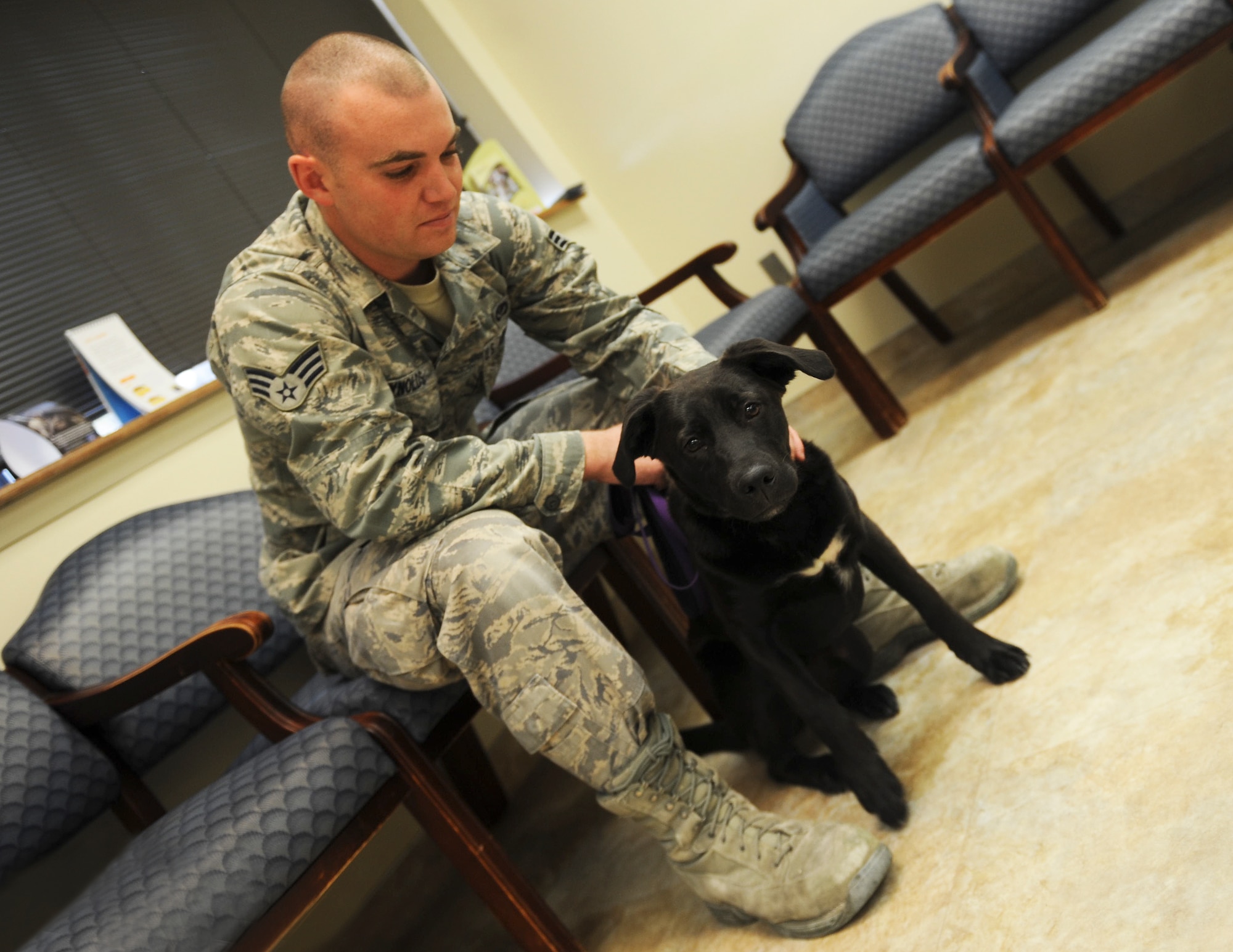 U.S. Air Force Senior Airman Matthew Reynolds, 23d Civil Engineer Squadron structural journeyman, and his dog, Dakota, sit in the Veterinary Treatment Facility waiting room at Moody Air Force Base, Ga., March 12, 2013. This was Dakota’s first visit to the veterinarian since being adopted by Reynolds. (U.S. Air Force photo by Airman 1st Class Olivia Bumpers/Released)