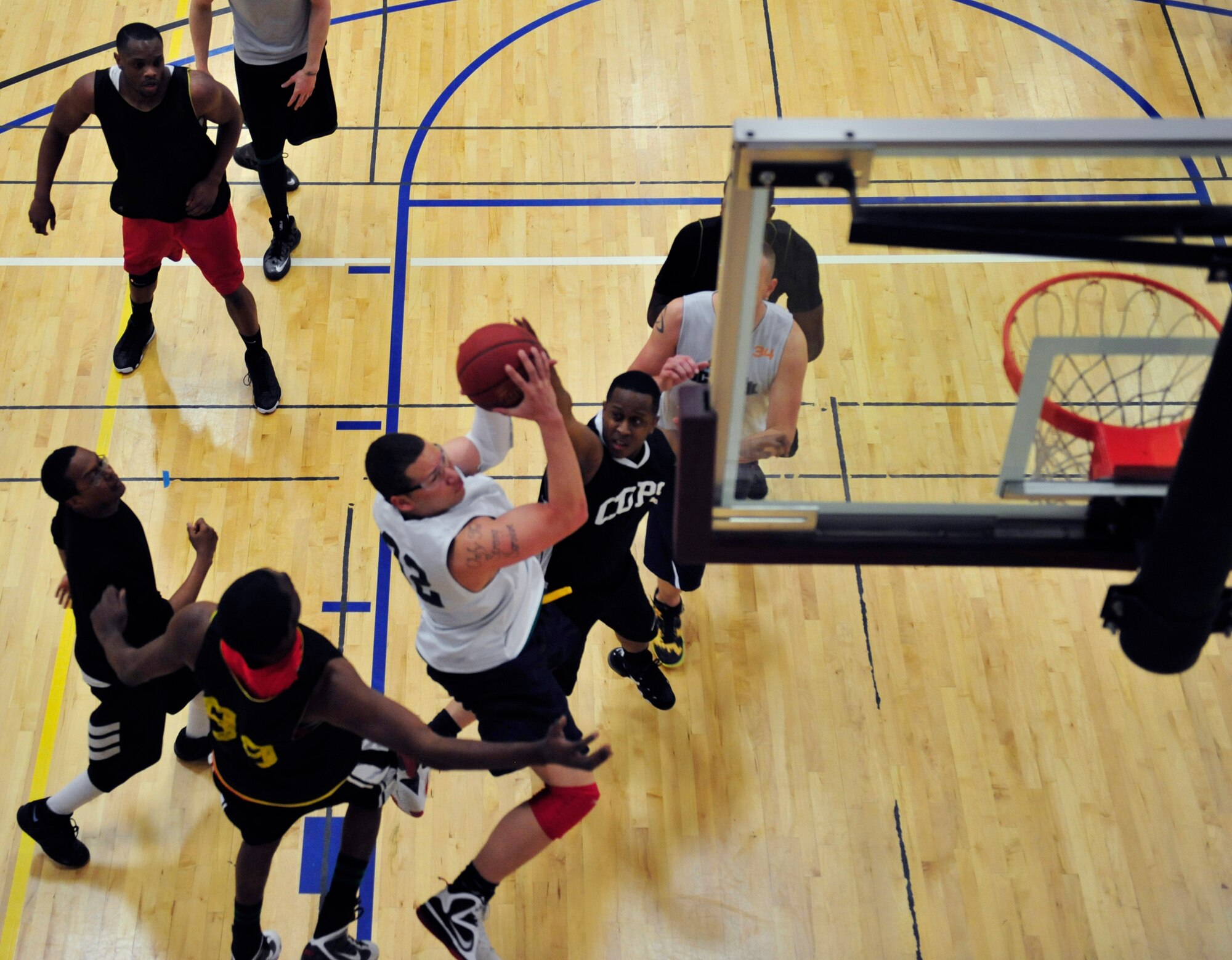 A member from the 566th Intelligence Squadron leaps for a layup against the 460th Security Forces Squadron intramural basketball team March 13, 2013, on Buckley Air Force Base, Colo. The 566th IS team suffered defeat in the base championship game. (U.S. Air Force photo by Airman 1st Class Darryl Bolden Jr. /Released)