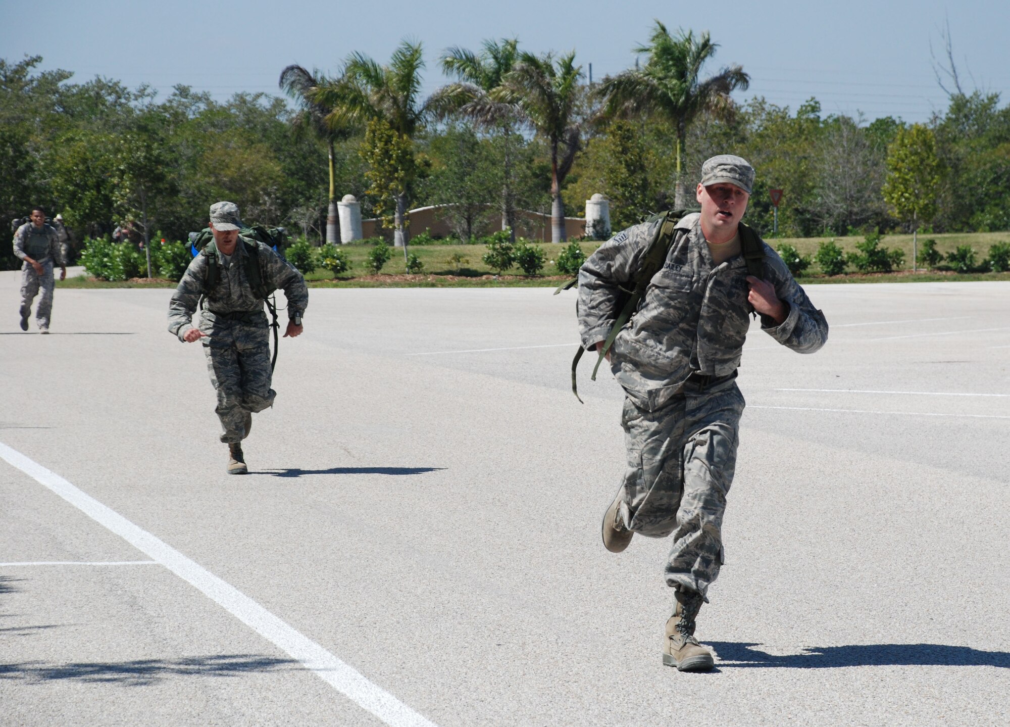 Staff Sgt. Andrew Bailey (front) and Master Sgt. James Moad, Special Operations Command South communications specialists, sprint to the finish line after completing a 4.5 mile ruck march during the SOCSOUTH Warrior Challenge at Homestead Bayfront Park March 8. The challenge featured several physical fitness and military skills events such as a 4.5 mile run, weapons malfunction and assembly station, and 4.5 mile ruck march. The event consisted of 21 teams assigned to SOCSOUTH competing for bragging rights among the unit. The competition allowed for members of the command to enjoy a day of fun and help build its esprit de corps. The event ended with a command barbeque. (DOD photo by Army Capt. Daisy Bueno, SOCSOUTH Public Affairs)