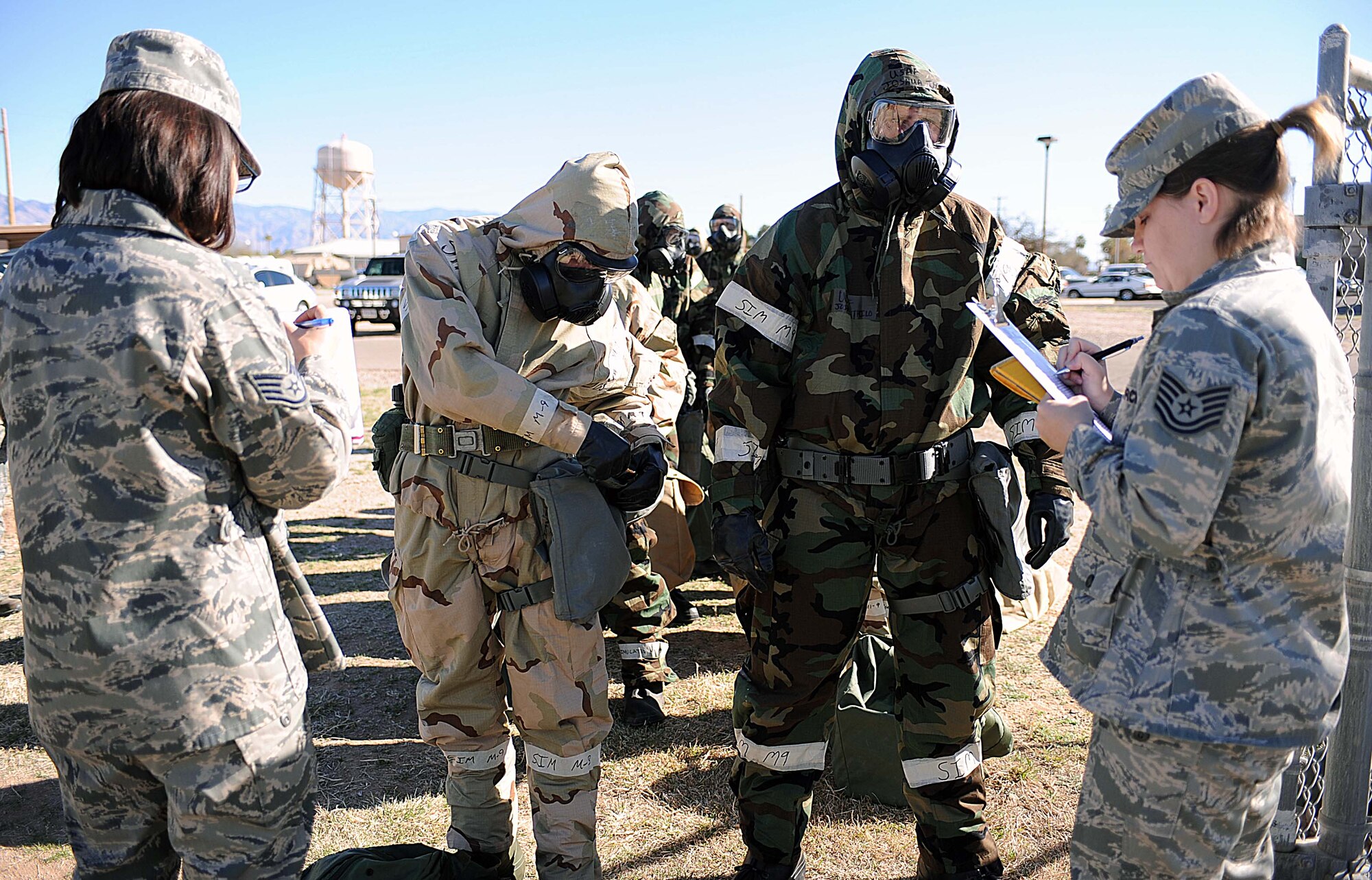 U.S. Air Force Staff Sgt. Lisa Brow and Tech. Sgt. Shawna Hopp, 355th Civil Engineer Squadron exercise evaluation team, perform mission oriented protective posture equipment checks on player Airmen from the 355th Fighter Wing on Davis-Monthan Air Force Base, Ariz., March 13, 2013. Airmen processed through the contamination control area as part of their training during the exercise. (U.S. Air Force photo by Airman 1st Class Christine Griffiths/Released)