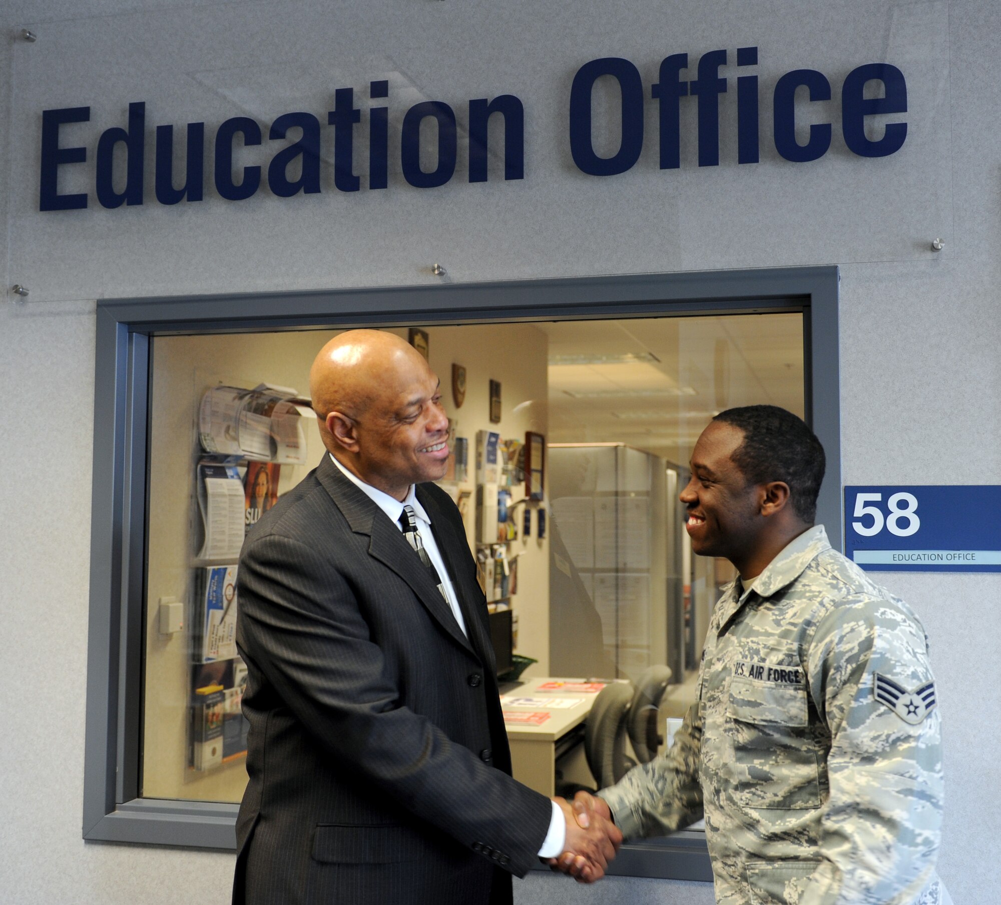 Roland Smith, Education and Training Center education manager, greets Senior Airman Gerald Campbell, 375th Aeromedical Evacuation Squadron radio operator, a junior who attends the American Military University.  Smith helps military members throughout their college journey.  (U.S. Air Force photo/Staff Sgt. Maria Bowman)