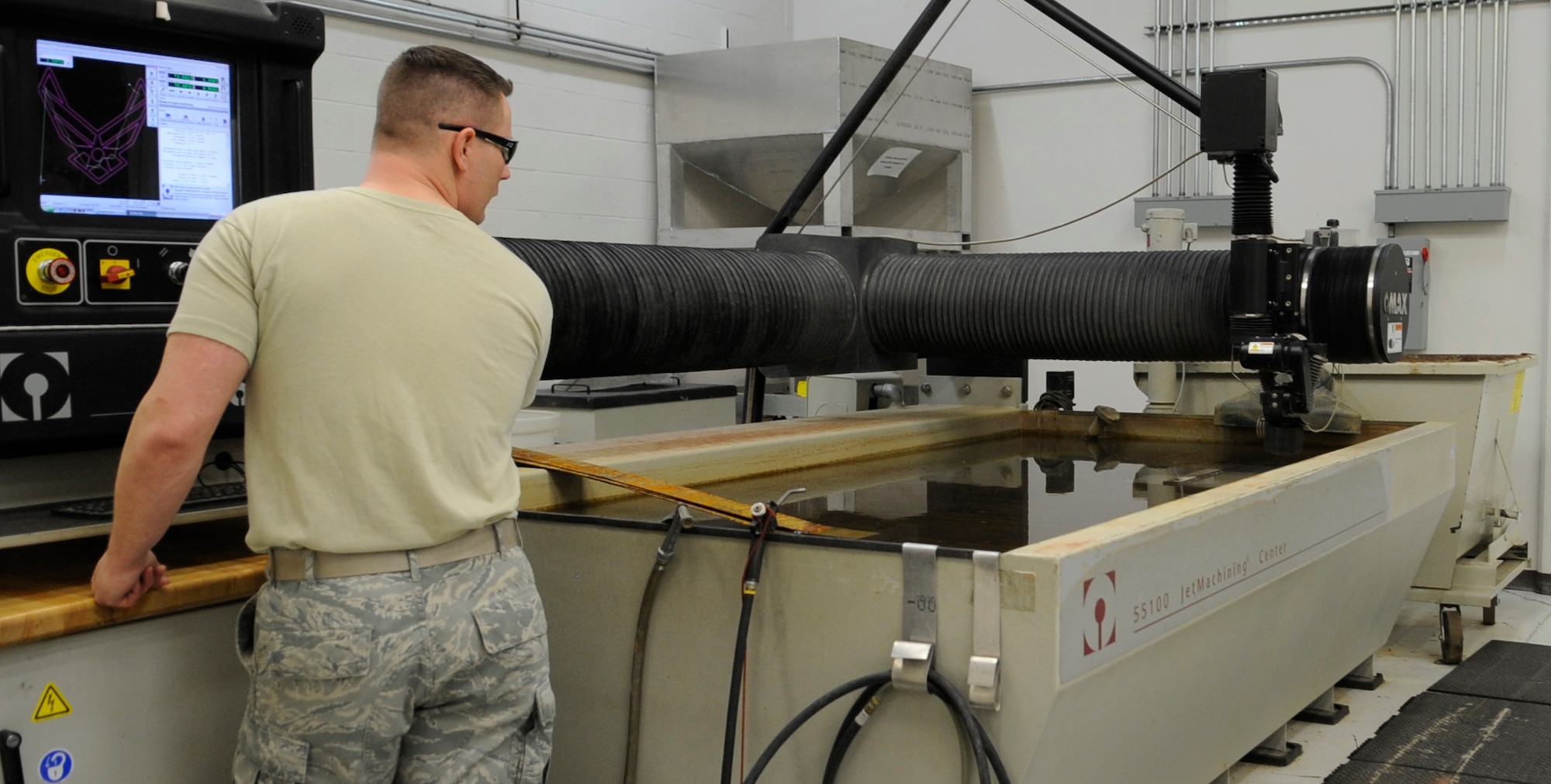 WHITEMAN AIR FORCE BASE, Mo. – U.S. Air Force Tech. Sgt. Jim Gargano, 509th Maintenance Squadron metals technology assistant section chief, uses a water jet machine to cut pieces of metal for aircraft parts, Mar. 6. Speed, productivity and efficiency are benefits of water jet cutting. (U.S. Air Force photo/Staff Sgt. Alexandra M. Boutte) (RELEASED)