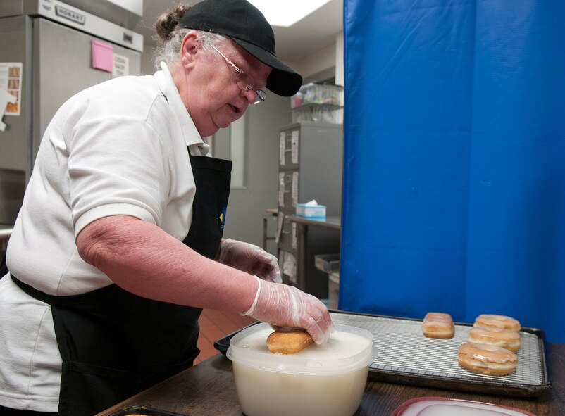 Barbara Damoude glazes donuts and other pasties, preparing them for the oven March 10, at the F. E. Warren Air Force Base Commissary. (U.S. Air Force photo by R.J. Oriez) 