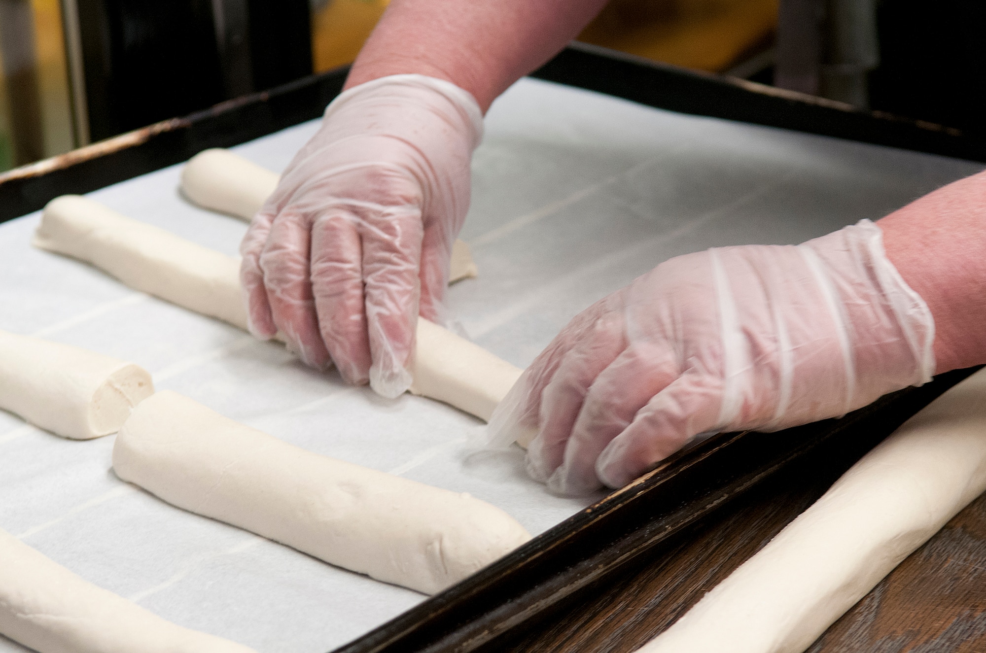 Dough for smaller loaves of French bread is shaped on a baking sheet before being put into a proofer to rise in the F. E. Warren Air Force Base Commissary Bakery March 10. (U.S. Air Force photo by R.J. Oriez)