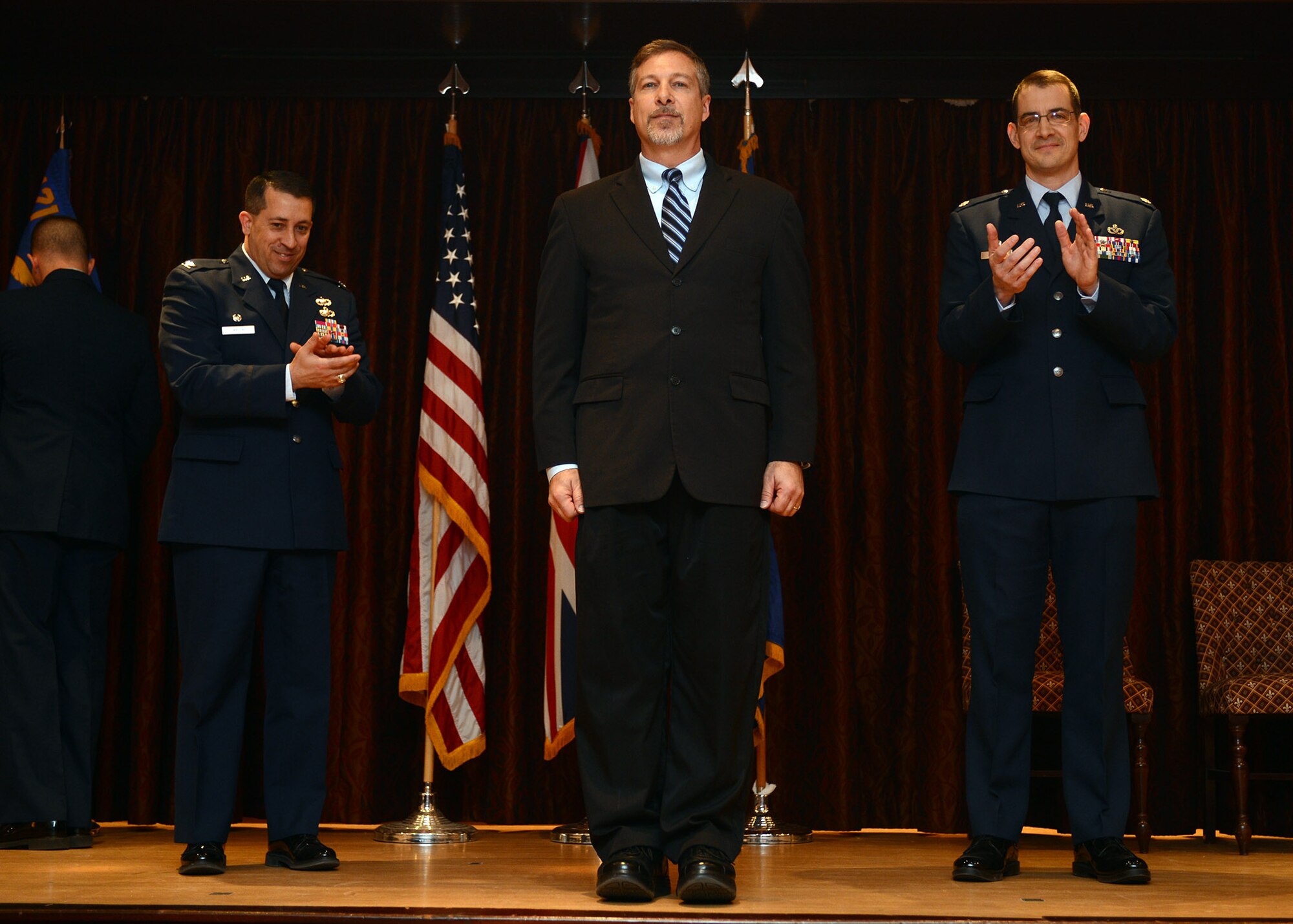RAF MENWITH HILL, United Kingdom – Michael Rits, the new 421st Civil Engineer Squadron commander, receives a round of applause from Col. Brian Kelly, 501st Combat Support Wing commander, and Lt. Col. Brad Buckman, former 421st CES commander, during a Change of Command Ceremony March 13. (U.S. Air Force photo by Staff Sgt. Debbie Lockhart)