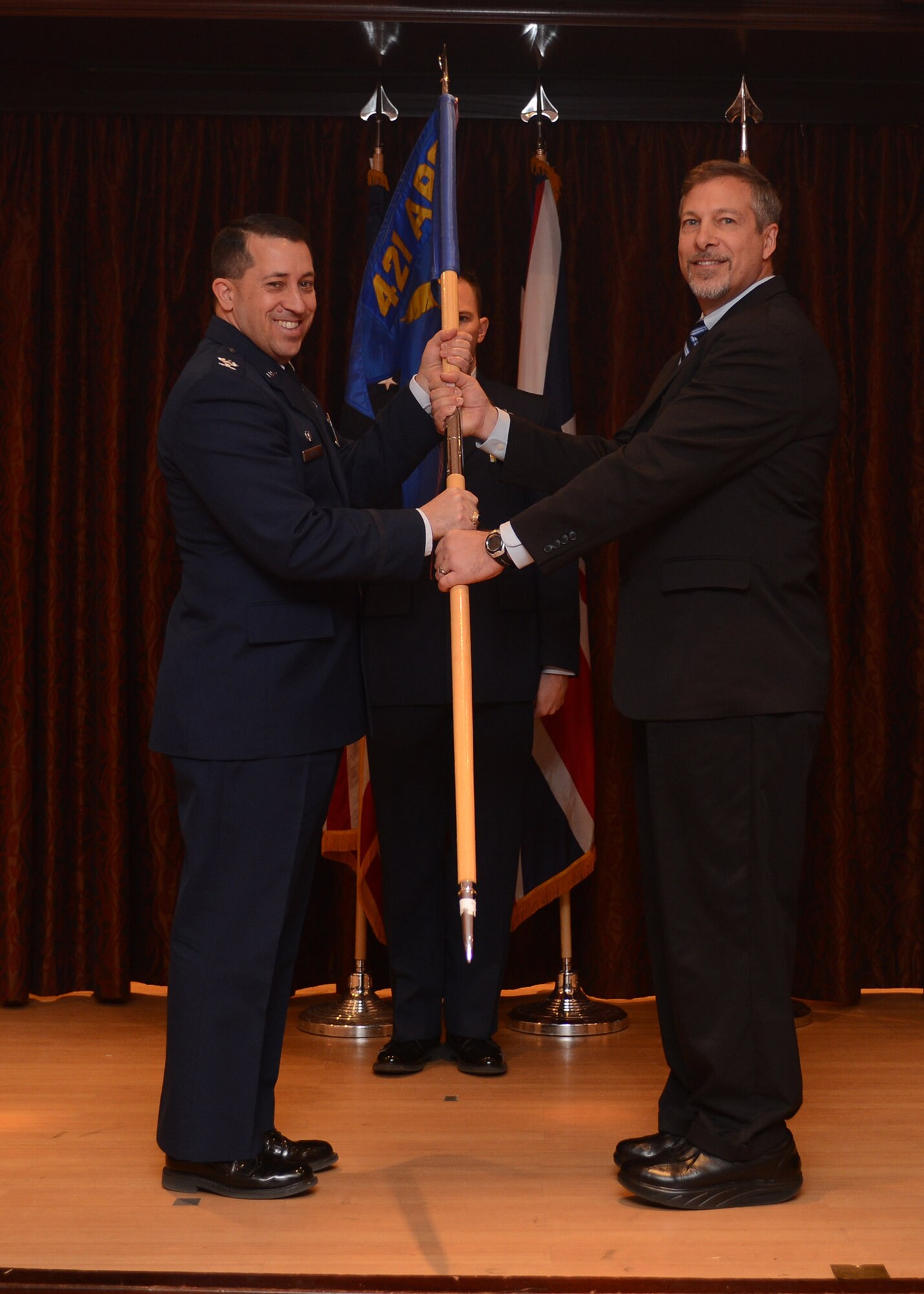 RAF MENWITH HILL, United Kingdom – Col. Brian Kelly, 501st Combat Support Wing commander, presents command of the 421st Civil Engineer Squadron to Michael Rits during a change of com-mand ceremony March 13. Rits assumed command as the first civil-ian commander of the 421st CES, marking the unit’s transition to an all-civilian squadron. The previous commander, Lt. Col. Brad Buck-man, serves as the deputy commander, 421st Air Base Group. (U.S. Air Force photo by Staff Sgt. Debbie Lockhart)