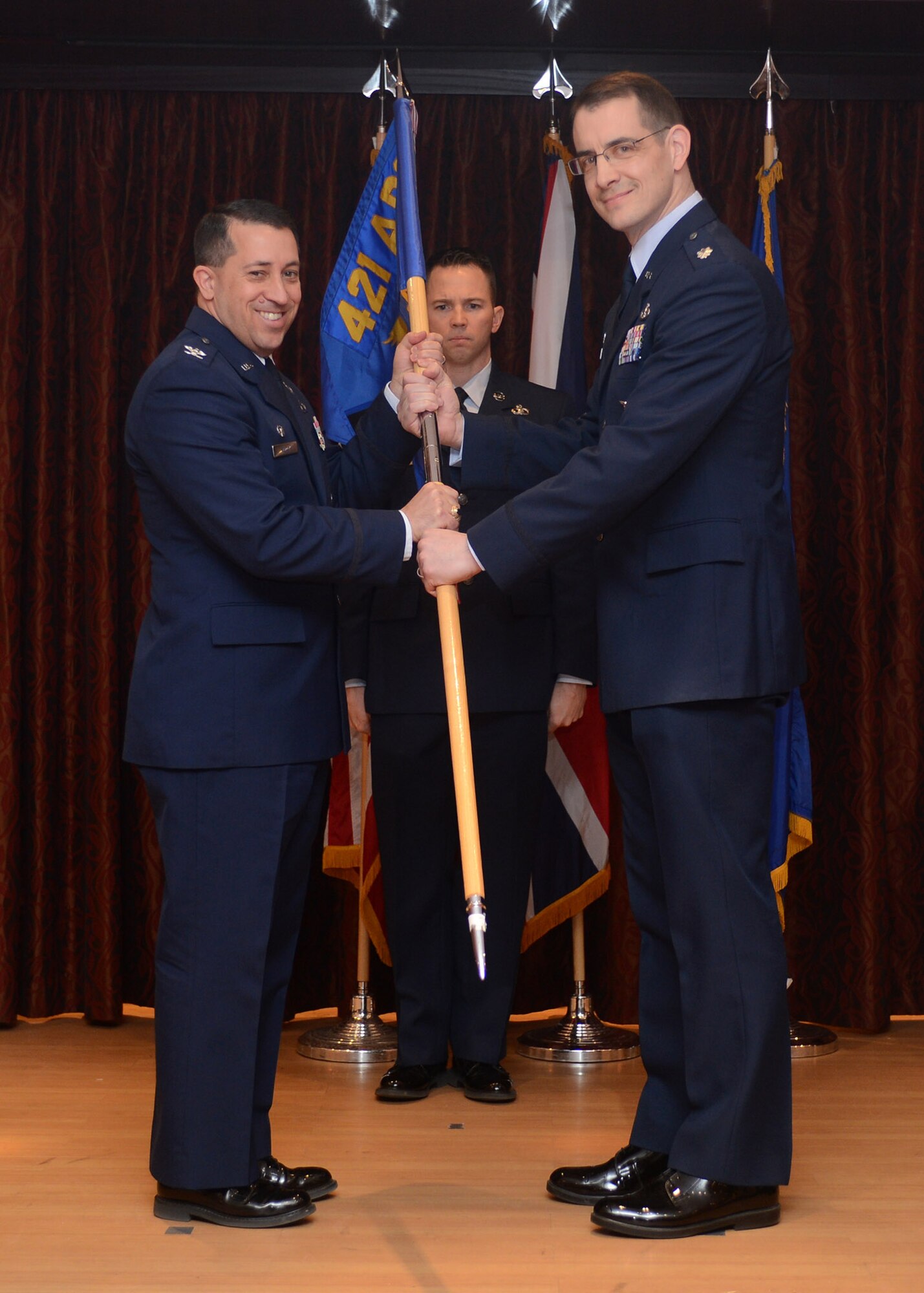 RAF MENWITH HILL, United Kingdom – Lt. Col. Brad Buckman relinquishes command of the 421st Civil Engineer Squadron and passes the squadron guidon to Col. Brian Kelly, 501st Combat Support Wing commander, during a Change of Command Ceremony March 13. Michael Rits assumed command during the ceremony. (U.S. Air Force photo by Staff Sgt. Debbie Lockhart)