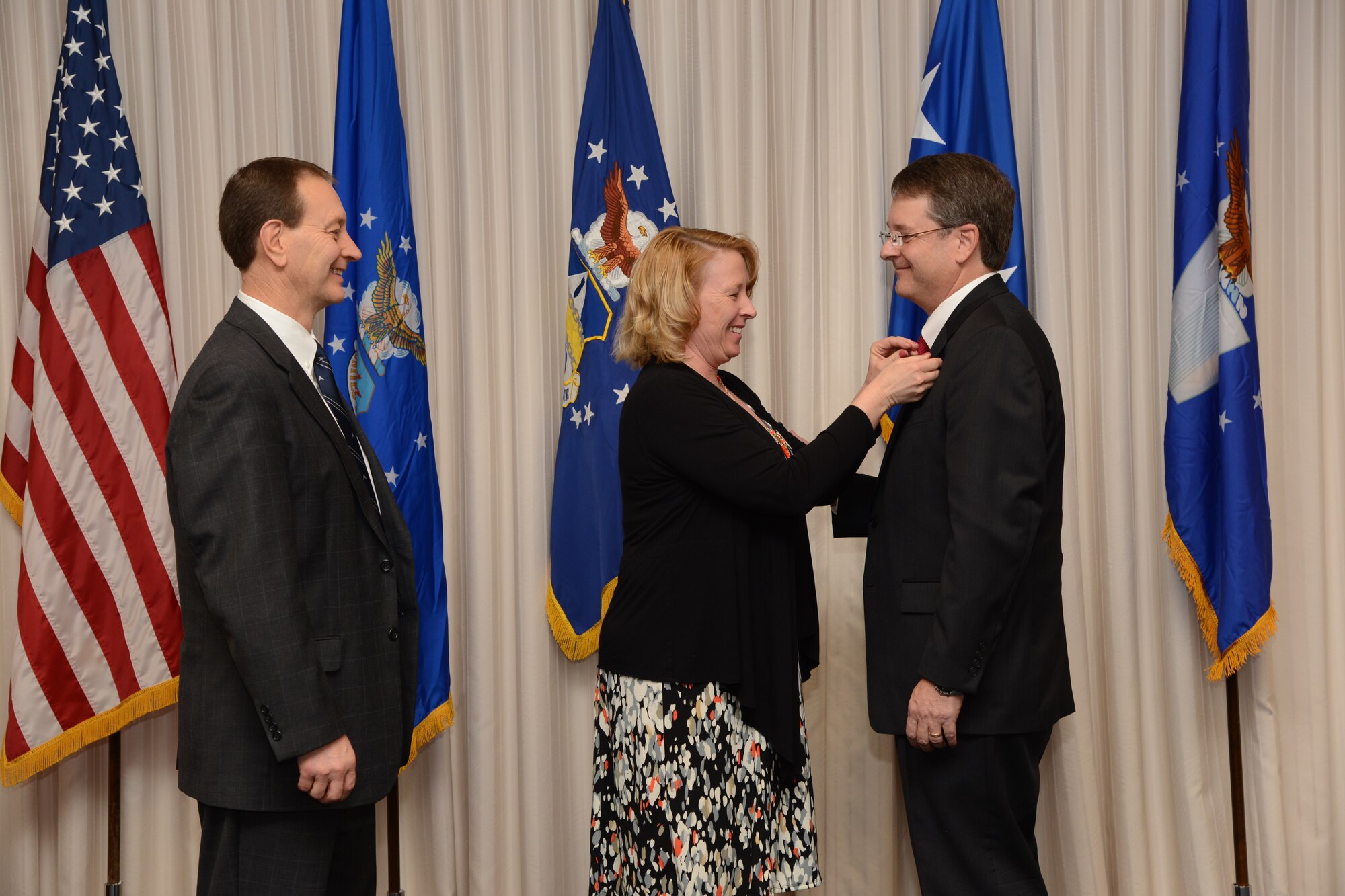 Lisa Alsup pins the Senior Executive Service pin onto her husband, Steven Alsup’s, lapel. The promotion and appointment of leadership ceremony on March 8 in the Anaconda Room in Bldg. 3001 saw Mr. Alsup not only get promoted into Senior Executive Service, but also become the new director of the 448th Supply Chain Management Wing. (Air Force photo by Kelly White)