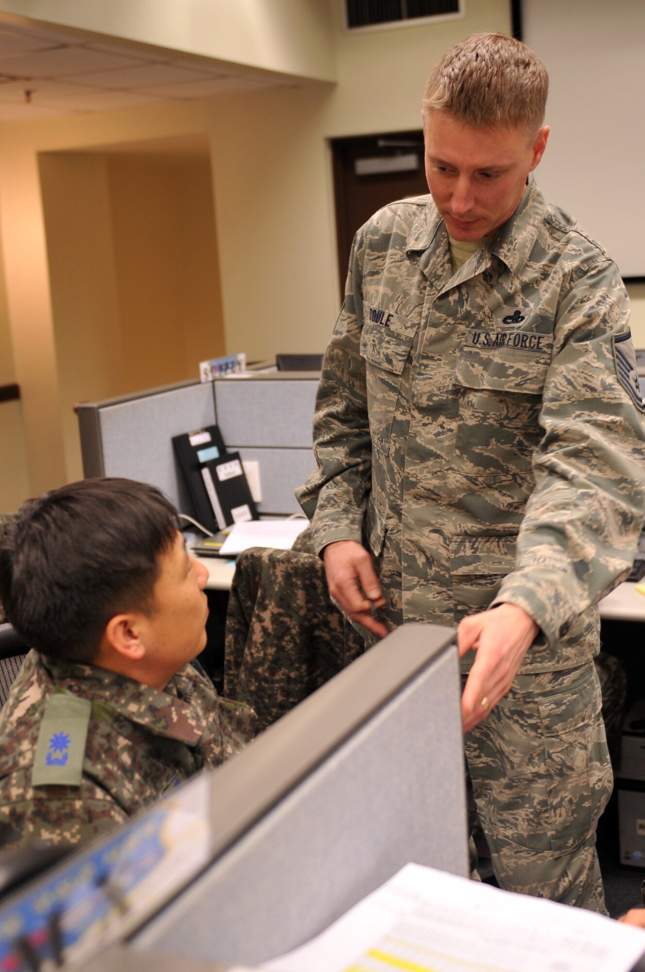 Republic of Korea Air Force Maj. Lee, Oh Sung speaks with U.S. Air Force Master Sgt. Richard Soule, 7th Air Force logistics cell staff member, at the Combined Air Logistics Center during Exercise Key Resolve on Osan Air Base, Republic of Korea, March 15, 2013. "(When we train) with them in exercises, as well as our day to day operations, we have cohesion, camaraderie, we’ve identified things we need to work on for improvement and if there is any type of contingency, we’re more prepared to go ahead and execute the mission," said Capt. Sarah Thompson, 7th Air Force officer in charge of plans and resources. (U.S. Air Force photo/Airman 1st Class Hailey R. Davis) 