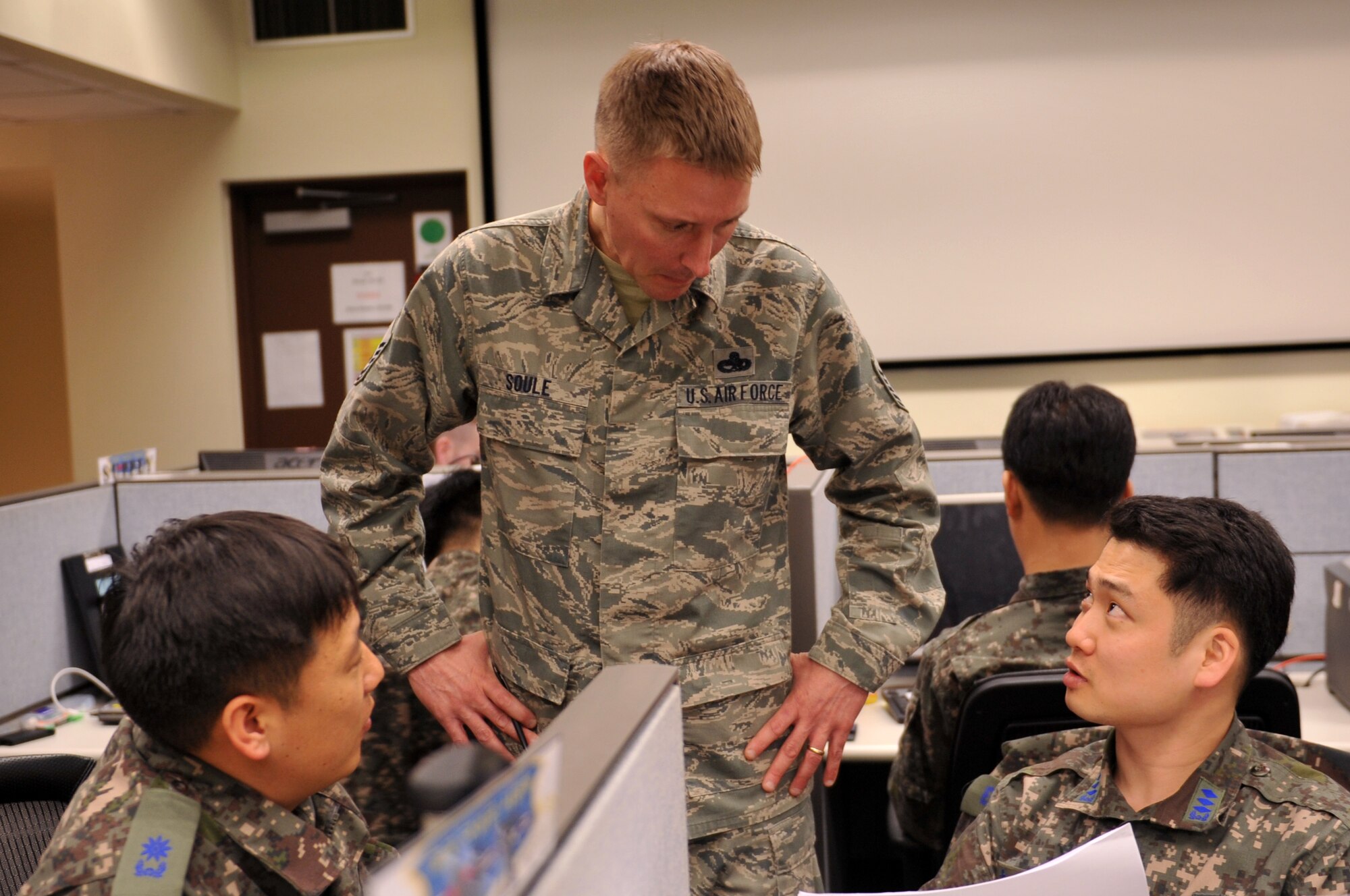Republic of Korea Air Force Maj. Lee, Oh Sung and Capt. Woo, Si Hyeong, ROKAF logistics, speak with U.S. Air Force Master Sgt. Richard Soule, 7th Air Force logistics cell staff member, at the Combined Air Logistics Center during Exercise Key Resolve on Osan Air Base, Republic of Korea, March 15, 2013. The logistics center provides a source of combined information with logistics resources to support planned combat operations and any resource shortfalls. (U.S. Air Force photo/Airman 1st Class Hailey R. Davis)