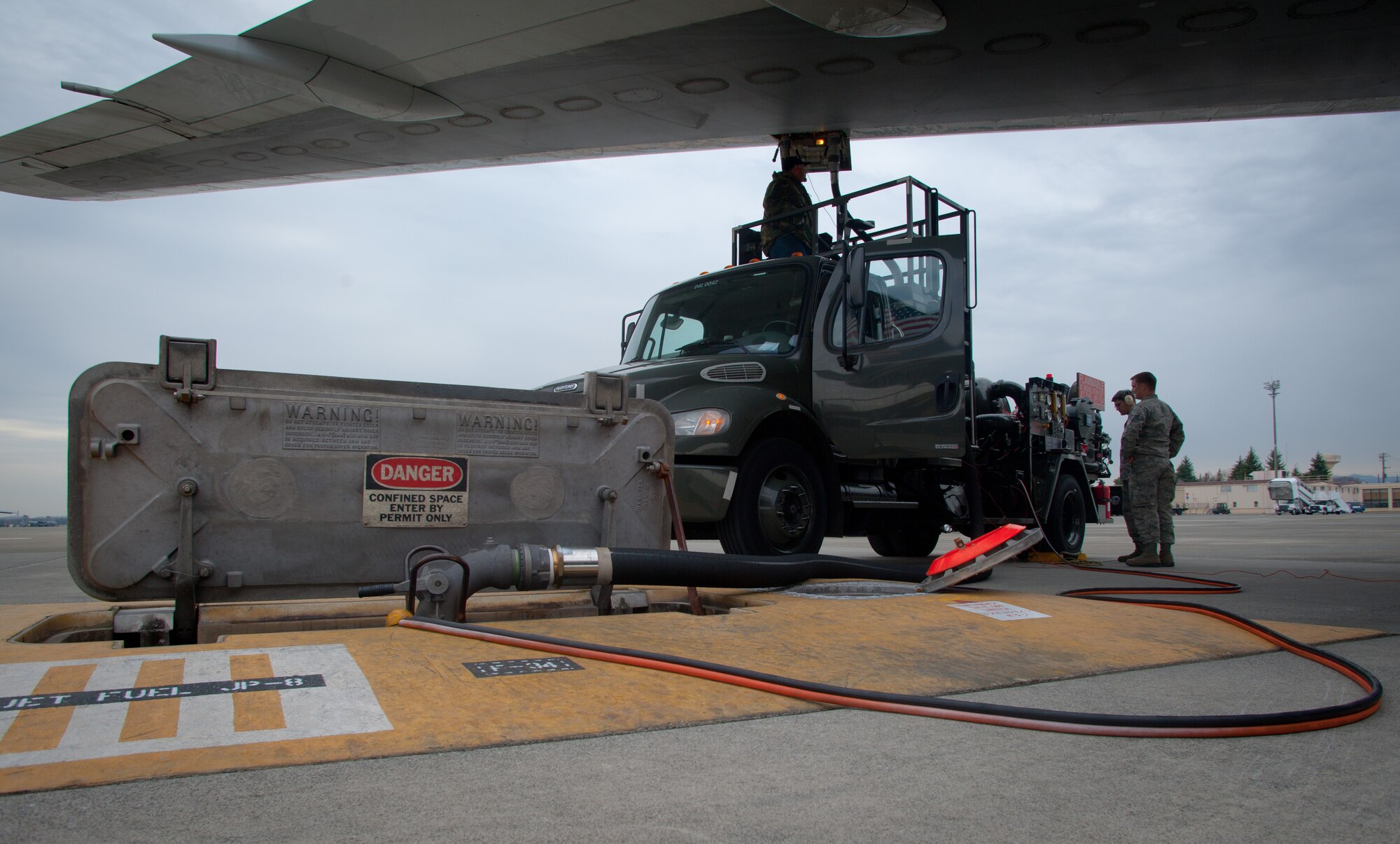 YOKOTA AIR BASE, Japan -- From right to left, Staff Sgt. Samuel Aldrich, 374th Logistics Readiness Squadron fuels distribution non-commissioned officer in charge and Airman 1st Class Trevor Kling, 374 LRS fuels distribution operator, team with a civilian contractor to fuel a contracted aircraft at Yokota Air Base, Japan, March 14, 2013. The dedicated Airmen from the fuels distribution team and preventative maintenance work together to fuel aircraft at and transiting through Pacific Air Force's airlift wing. (U.S. Air Force photo by 1st Lt. Christopher Love) 