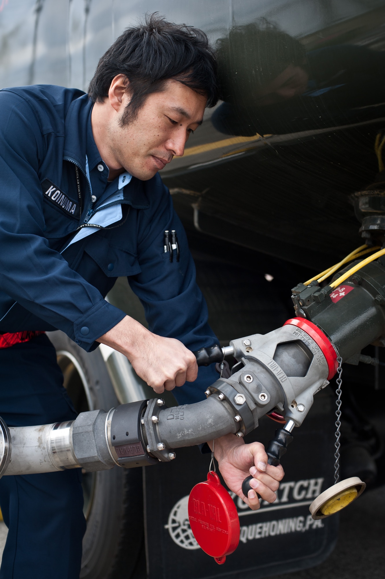 YOKOTA AIR BASE, Japan -- Makoto Koinuma, 374th Logistics Readiness Squadron fuels distribution operator, demonstrates how to clamp a refueling hose onto an R-11 refueling truck at Yokota Air Base, Japan, March 15, 2013. Like many Yokota organizations, the 374 LRS consists of both U.S. and Japanese members working alongside to ensure the base is ready to respond to contingencies. (U.S. Air Force photo by 1st Lt. Christopher Love) 