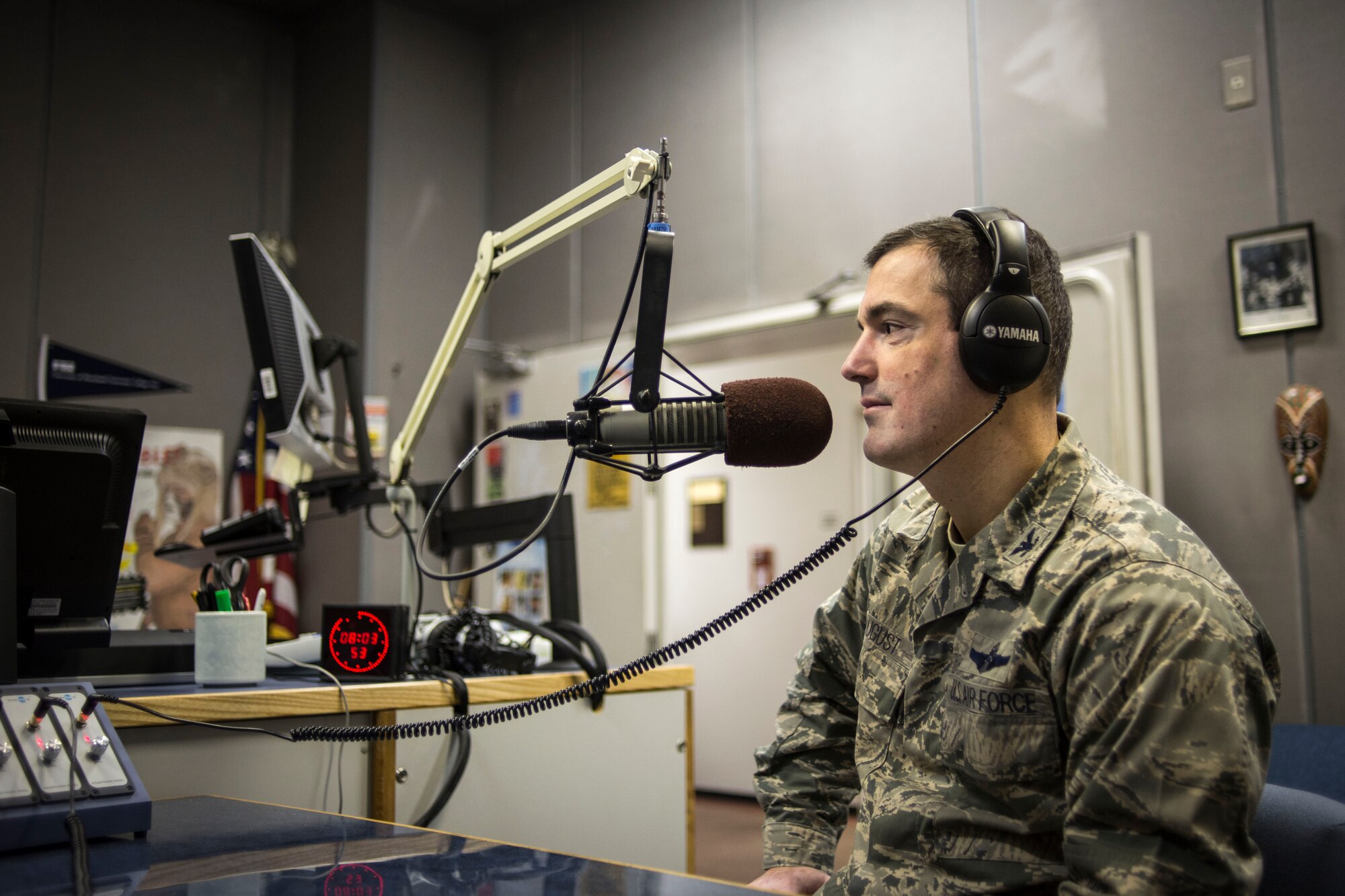 Col. Mark August, 374th Airlift Wing commander speaks on the Armed Forces Network’s Eagle 810 radio at Yokota Air Base, Japan, March 15, 2013. During a live in-studio radio interview, the commander updated base residents on the wing’s budget and addressed concerns from the Yokota community. (U.S. Air Force photo illustration by Capt. Raymond Geoffroy)