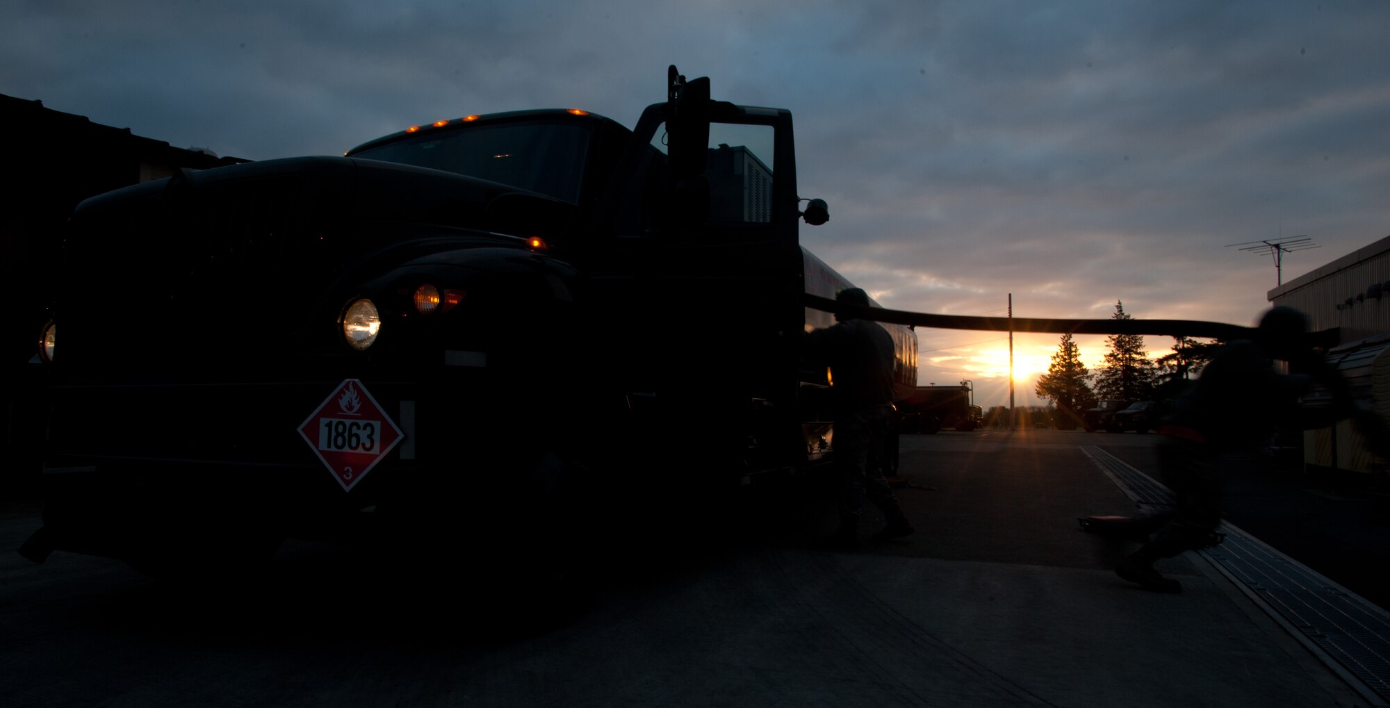 YOKOTA AIR BASE, Japan -- The sun rises in the distance as an Airman from the 374th Logistics Readiness Squadron preventative maintenance team unwinds a fueling hose on an R-11 refueling truck at Yokota Air Base, Japan, March 15, 2013. By inspecting these vehicles each day, the "loggies" ensure the fleet's readiness to respond to short-notice taskings. (U.S. Air Force photo by 1st Lt. Christopher Love) 