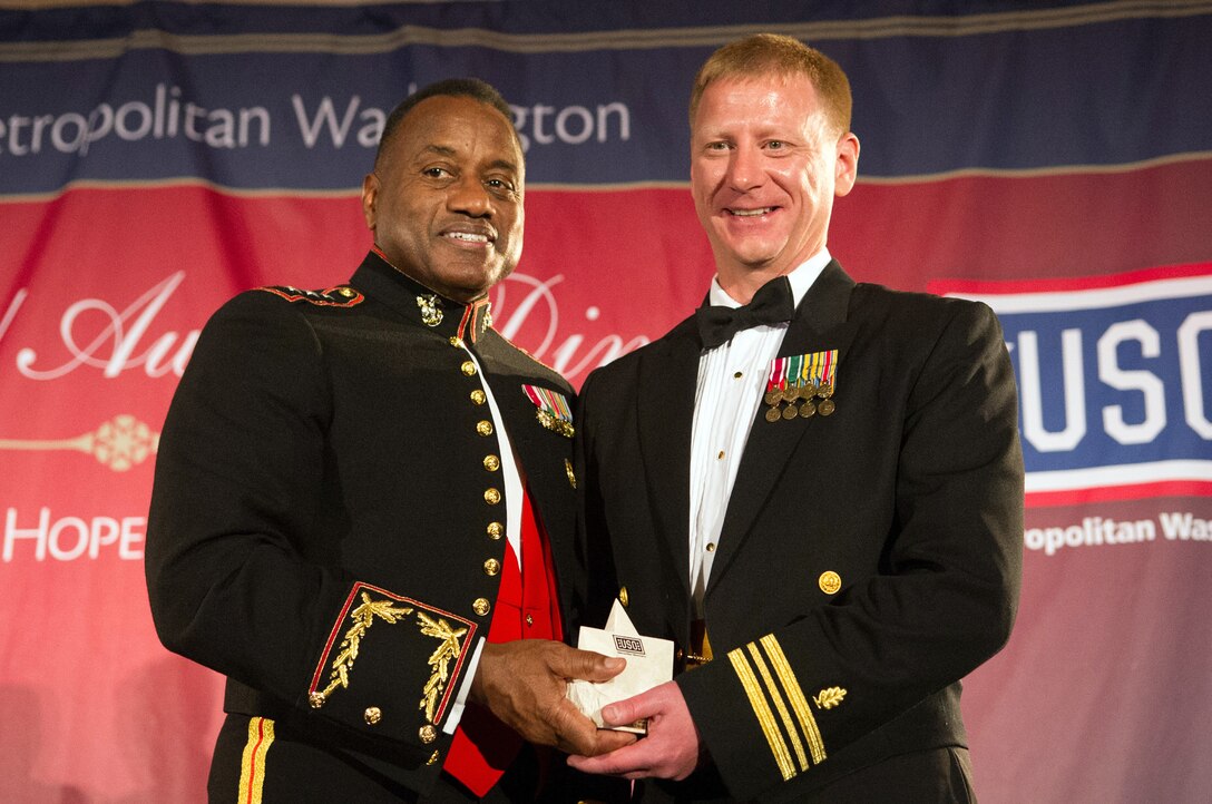 Marine Corps Lt. Gen. Willie Williams, left, director of Marine Corps staff, presents a special salute award to Navy Lt. Cmdr. Trevor Petrou, a physical therapist specialist serving in the Navy's Medical Service Corps, during the USO of Metropolitan Washington’s 31st awards dinner in Arlington, Va., March 14, 2013.