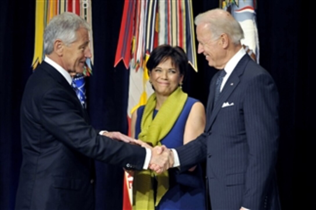 Secretary of Defense Chuck Hagel, left, is congratulated by Vice President Joe Biden after he is ceremonially sworn in as 24th secretary of defense while his wife Lilibet holds the Bible in a ceremony in the Pentagon on March 14, 2013.  