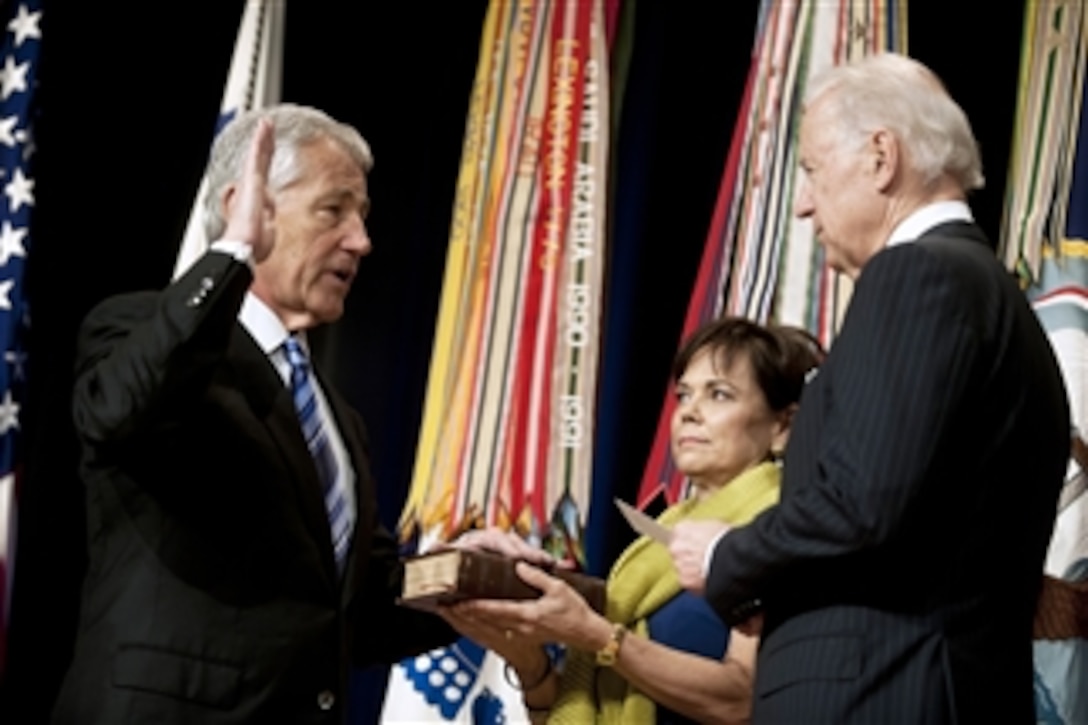 Vice President Joe Biden, right, administers the oath of office to Secretary of Defense Chuck Hagel as his wife Lilibet holds the Bible during a ceremonial swearing in at the Pentagon on March 14, 2013.  Hagel is the 24th secretary of defense.  