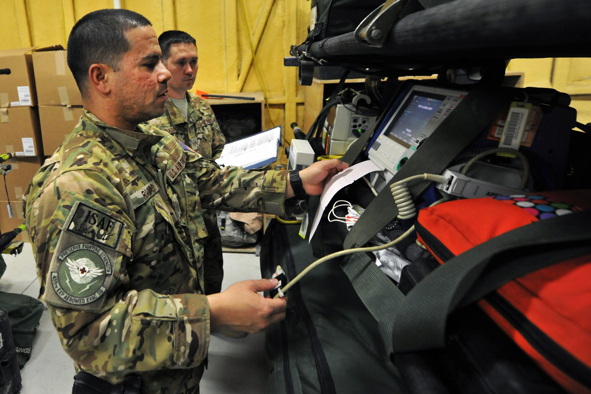 Tech. Sgt. Alejandro Rojas and Staff Sgt. Anthony Bradford, 455th Expeditionary Aeromedical Evacuation Squadron technicians, perform an equipment check before a mission on Bagram Airfield, Afghanistan, Feb. 21, 2013. The 455th EAES perform their missions on fixed wing aircraft, including the C-17 Globemaster III, C-130 Hercules and KC-135 Stratotanker, and can provide extensive critical care capability with the Critical Care Air Transport Teams. (U.S. Air Force photo/Senior Airman Chris Willis)