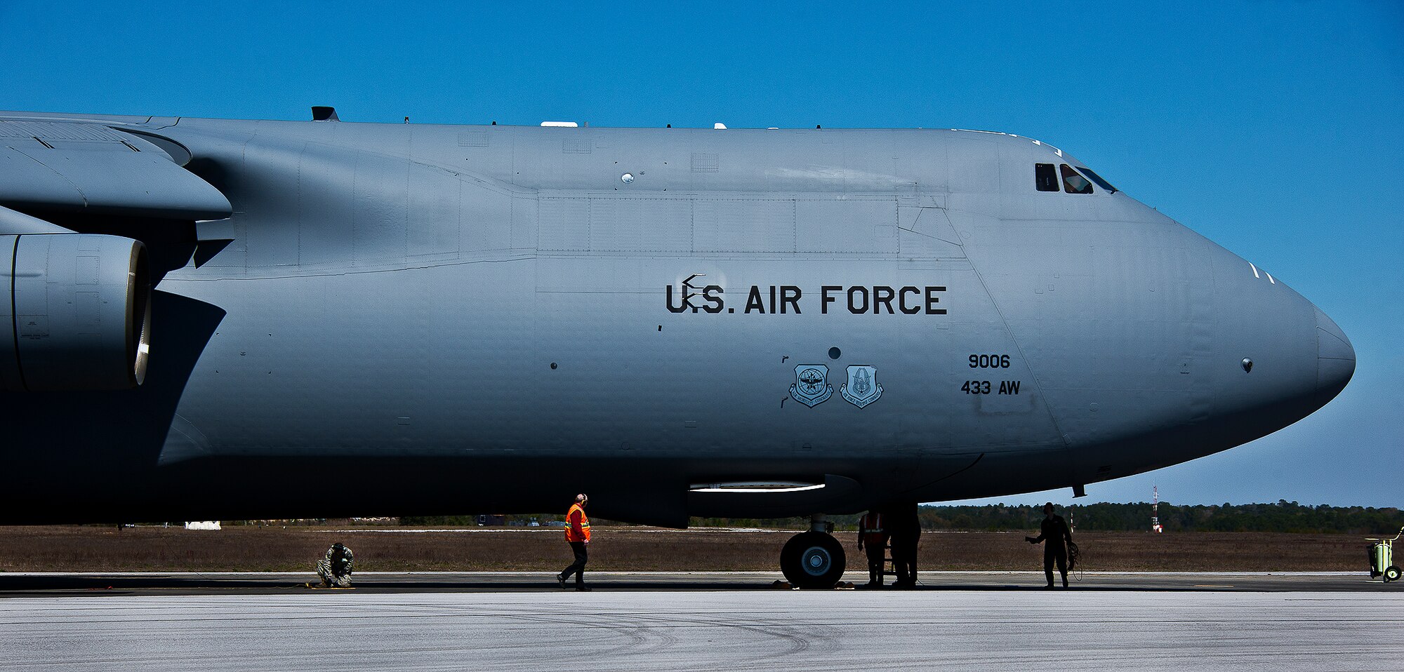 Aircrew and maintenance workers move around the 433rd Airlift Wing’s C-5 Galaxy just after it arrived at Eglin Air Force Base, Fla., March 14.  The reserve wing’s aircraft brought maintenance equipment from the 482nd Fighter Wing to the base in preparation for the weapons system evaluation program taking place March 18-22.  (U.S. Air Force photo/Samuel King Jr.)