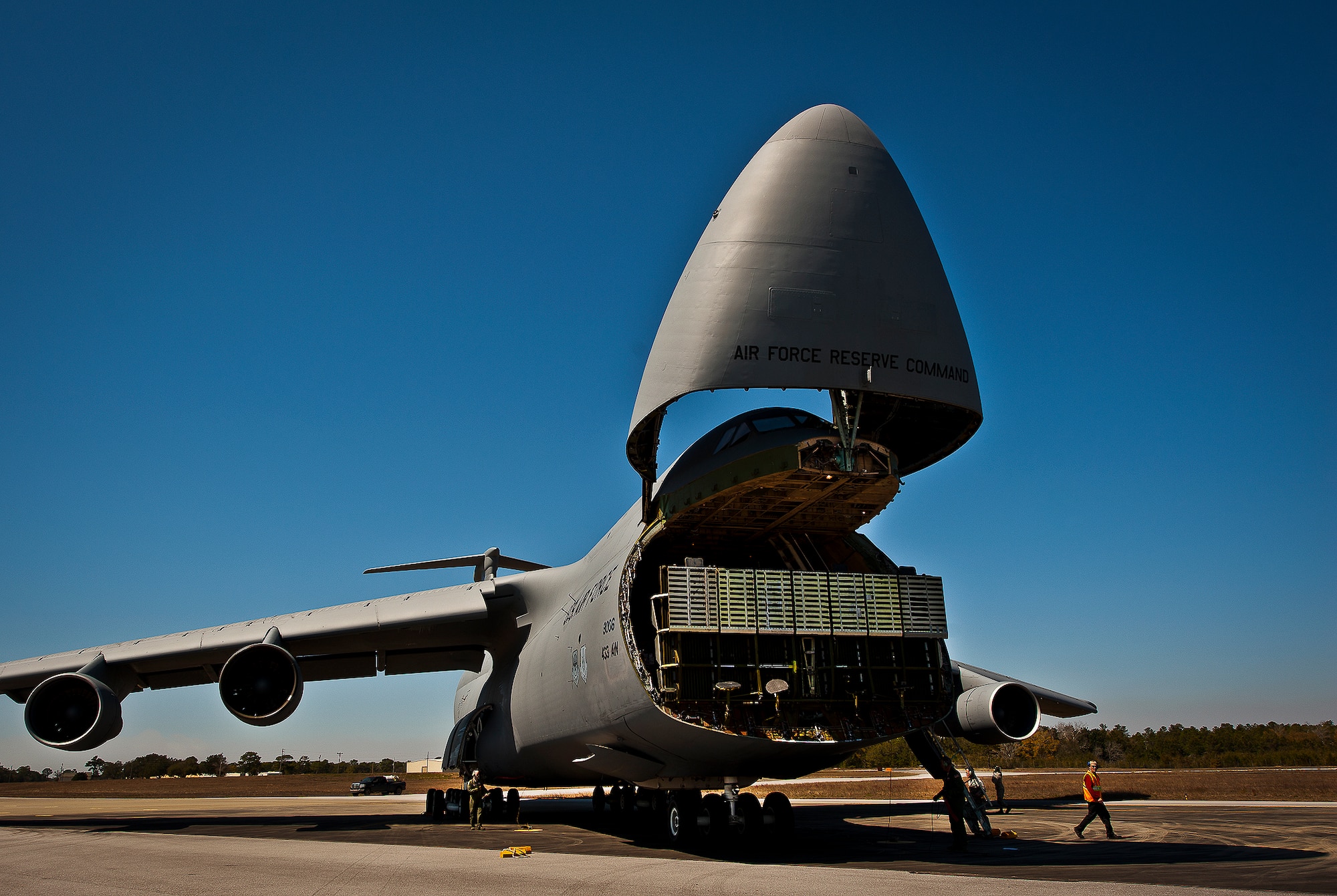 The nose of a C-5 Galaxy, from the 433rd Airlift Wing, lifts up so aircrew and 96th Test Wing air transportation Airmen can begin off-loading equipment at Eglin Air Force Base, Fla., March 14.  The reserve wing’s aircraft brought maintenance equipment from the 482nd Fighter Wing to the base in preparation for the weapons system evaluation program taking place March 18-22.  (U.S. Air Force photo/Samuel King Jr.)