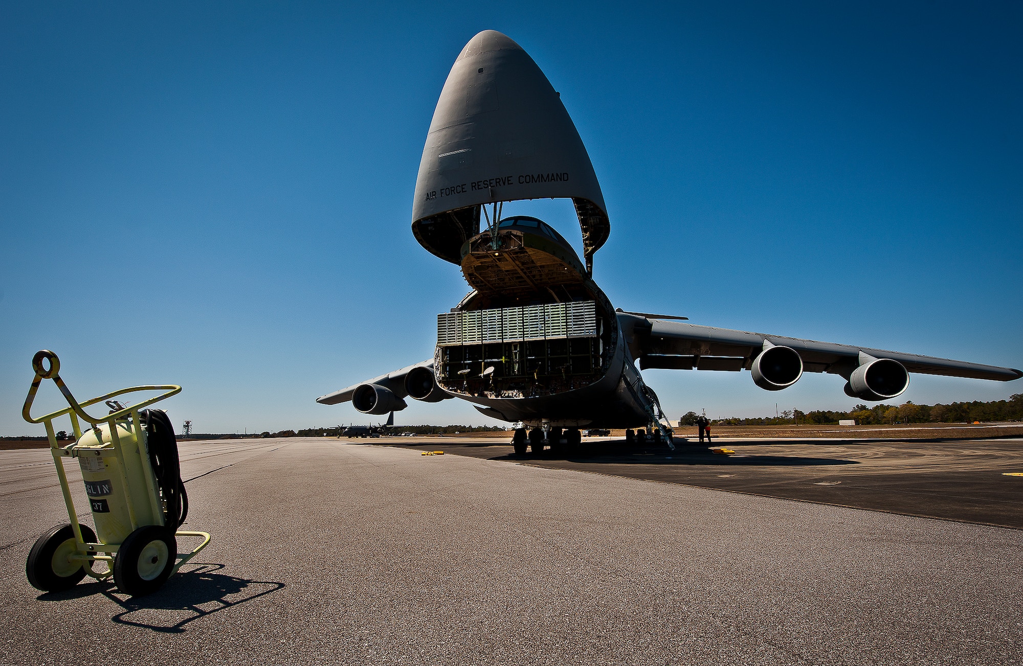 The nose of a C-5 Galaxy, from the 433rd Airlift Wing, lifts up so aircrew and 96th Test Wing air transportation Airmen can begin off-loading equipment at Eglin Air Force Base, Fla., March 14.  The reserve wing’s aircraft brought maintenance equipment from the 482nd Fighter Wing to the base in preparation for the weapons system evaluation program taking place March 18-22.  (U.S. Air Force photo/Samuel King Jr.)