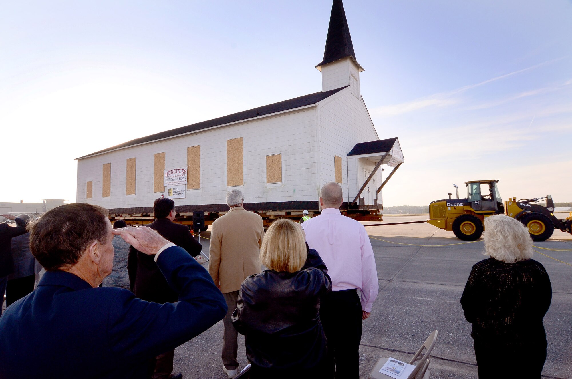 Honored guests watch as the Dobbins chapel begins its two mile trek to the south side of the base after an early morning ceremony honoring the Dobbins chapel, Dobbins ARB, Ga., March. 17. To meet post-9/11 security requirements, new construction of a perimeter road and parking lot at the chapel site dictated the chapel must be removed.  The private, non-profit Dobbins Chapel Foundation, 94th Airlift Wing and Georgia National Guard arrived at a solution at no cost to the government, to move the historic chapel across the base. (U.S. Air Force photo/Brad Fallin)