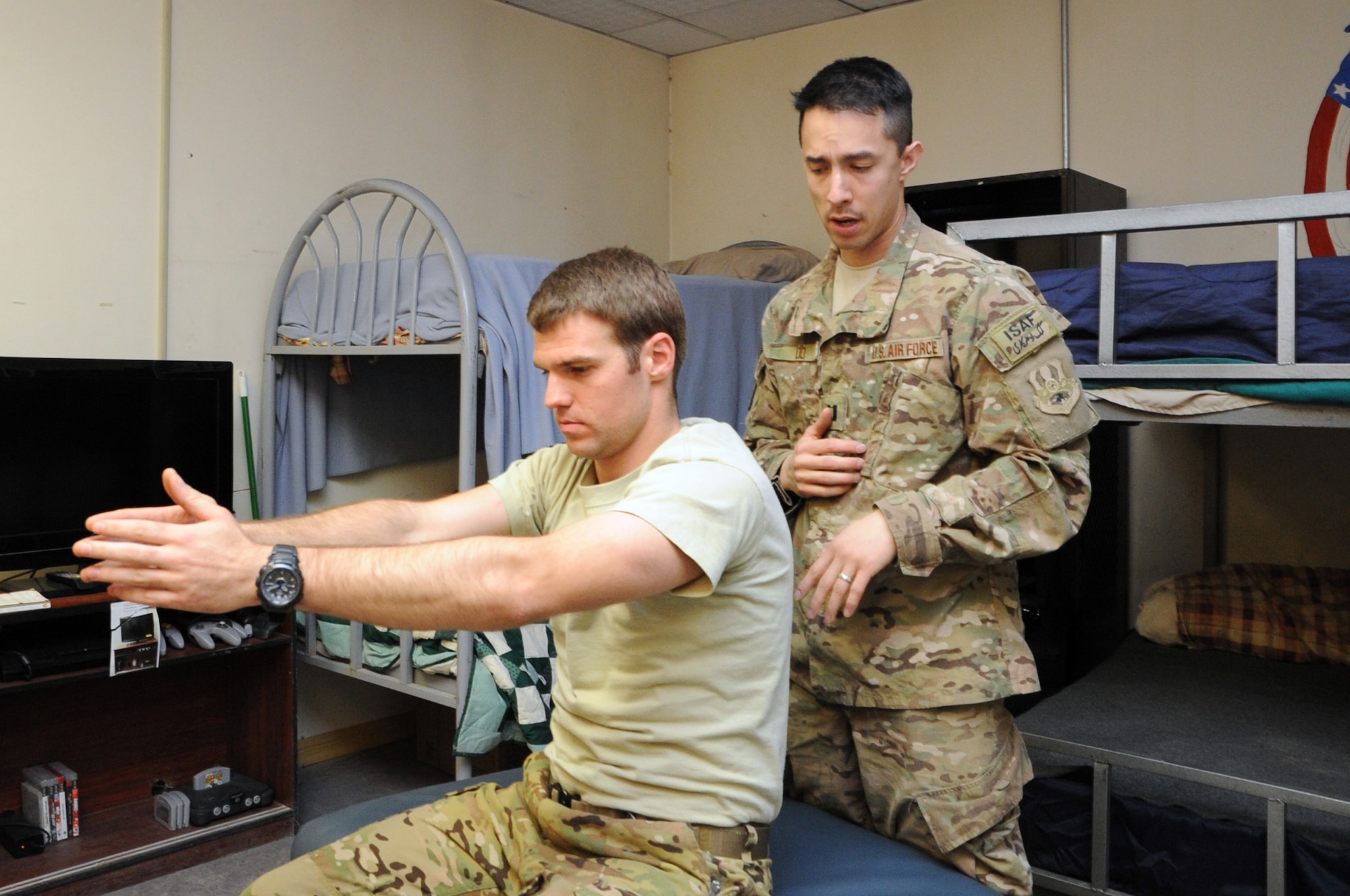 Capt. (Dr.) Kent Do, 455th Expeditionary Medical Operations Squadron physical therapist, conducts an examination of 1st Lt. Matthew Pfarr, 83rd Expeditionary Rescue Squadron pilot, at the 83rd ERQS building on Bagram Airfield, Afghanistan, March 14, 2013. Do regularly visits units to offer diagnoses and treatment to members who cannot get to the Craig Joint Theater Hospital. (U.S. Air Force photo/Staff Sgt. David Dobrydney)