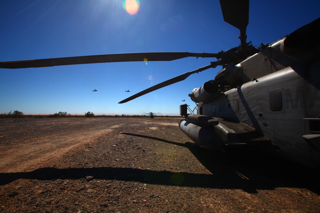 A CH-53E Super Stallion cools down at a forward area refueling point as MV-22 Ospreys fly in the distance during Operation Desert Tantrum outside of El Centro, Calif., March, 14. Marine Aircraft Group 16 brought together 27 aircraft in support of this training exercise to provide the most realistic training possible to prepare for future use in combat.