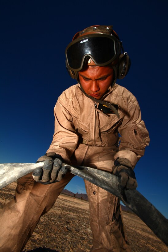 Lance Cpl. Antonio Guzman, a CH-53E Super Stallion crew chief with Marine Heavy Helicopter Squadron 466 and a Los Angeles native, untangles a fuel line at a forward area refueling point during Operation Desert Tantrum outside of El Centro, Calif., March, 14. Crew chiefs like Guzman set up refueling points for aircraft conducting training to refuel close to the training site rather than cutting training short to return to base.