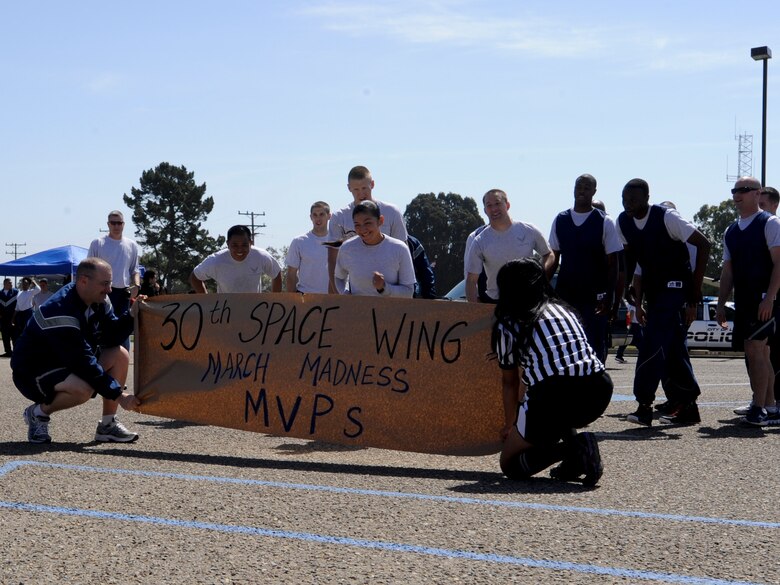 VANDENBERG AIR FORCE BASE, Calif. – The final four teams run through a banner outside the Pacific Coast Club before the ending basketball shoot-out here Friday, March 15, 2013. Wingman Day events gave more than 4,000 Team V members the opportunity to interact with one another and to learn about different topics such as branding yourself and interpersonal relationships. (U.S. Air Force photo/Airman Yvonne Morales)