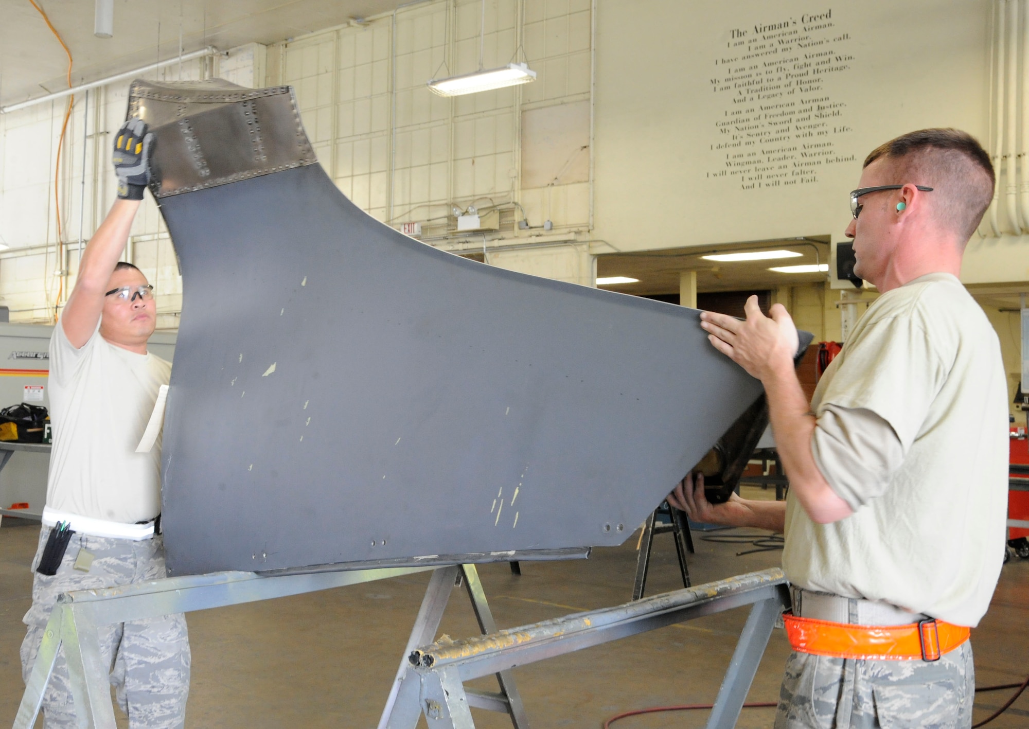 Staff Sgts. Steven Gutierrez and Jason Bliffen, both from the 2nd Maintenance Squadron Aircraft Structural Maintenance, flip a nacelle strut trailing edge for maintenance on Barksdale Air Force Base, La., March 18. The aircraft structural maintenance section has the responsibility of maintaining the structural integrity of the B-52H Stratofortress by removing corrosion, repairing cowlings and repainting the skin. (U.S. Air Force photo/Airman 1st Class Andrew Moua)