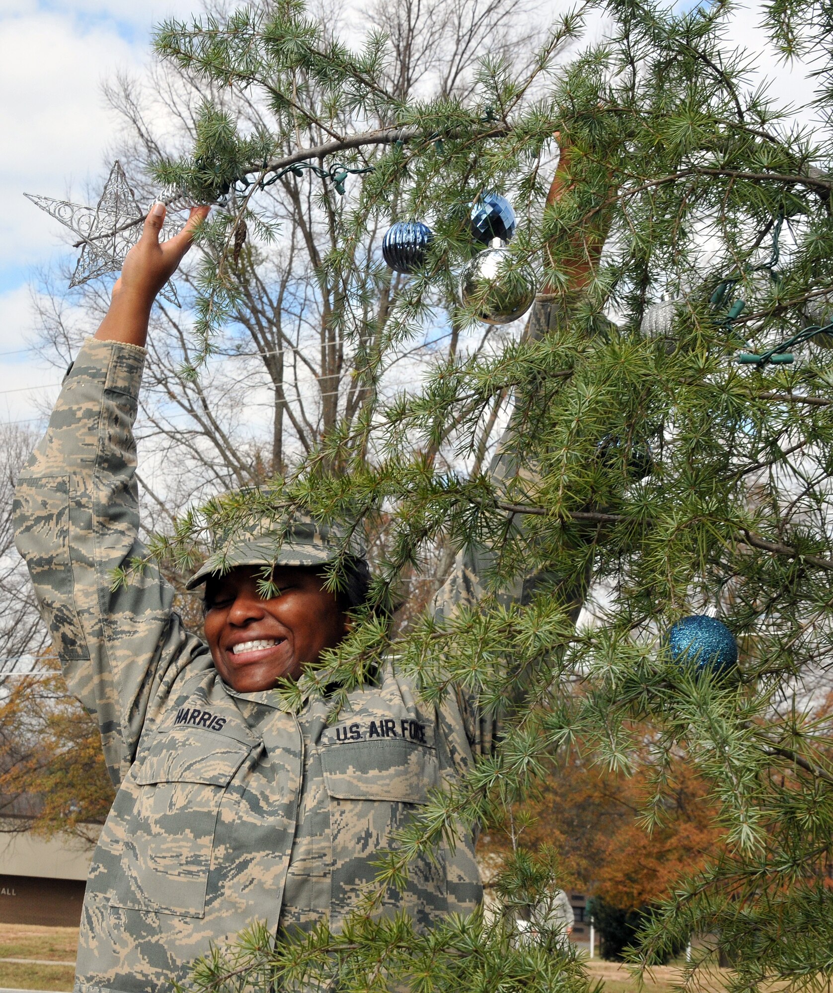 Airman First Class Shawnyse Harris, of the 94th Force Support Squadron, puts the star on top of the base holiday tree. Members of the First Four, on behalf of Chief Master Sgt. Wendell Peacock, 94th Airlift Wing command chief, invited Dobbins Air Reserve Base personnel out to decorate the base holiday tree near the front gate, Nov. 30.(U.S. Air Force photo/Senior Airman Elizabeth Van Patten)