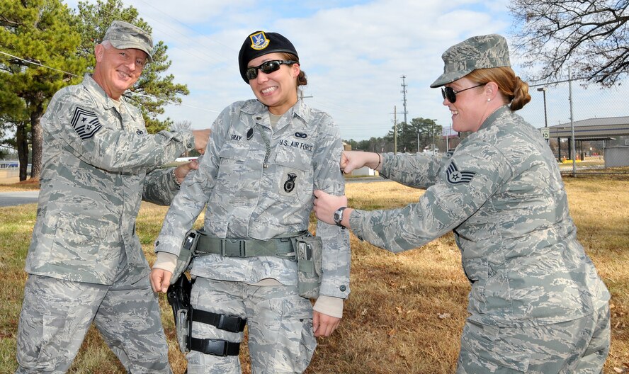 Chief Master Sgt. Wendell Peacock, 94th Airlift command chief, and Staff Sgt. Lindsey Black, 94th Airlift Wing broadcast specialist, celebrate with new Staff Sgt. Ashleigh Gray, of the 94th Securty Forces Squadron, on her promotion. Members of the First Four, on behalf  Peacock, invited Dobbins Air Reserve Base personnel out to decorate the base holiday tree near the front gate, Nov. 30.(U.S. Air Force photo/Senior Airman Elizabeth Van Patten)