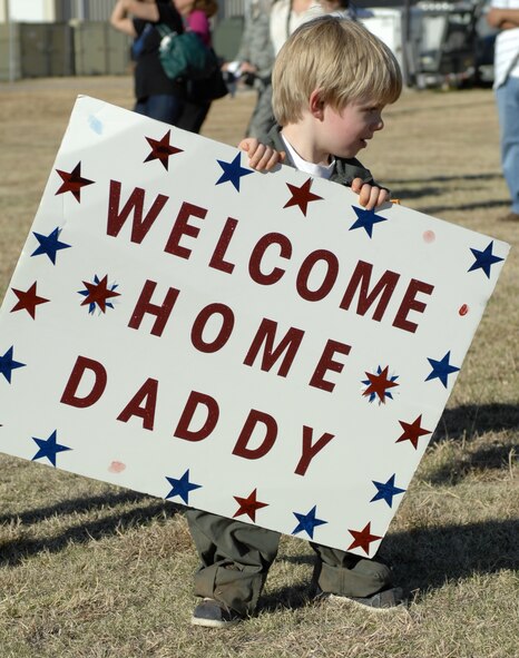 Teddy Arendsee, son of 1st Lt. Zacharee Arendsee, 40th Airlift Squadron, holds a welcome home sign while awaiting his father to de-board a C-130J March 15, 2013, at Dyess Air Force Base, Texas. For the first time in nearly a decade, the entire 317th Airlift Group fleet is back at their home station. (U.S. Air Force photo by Airman 1st Class Kylsee Wisseman/ Released)