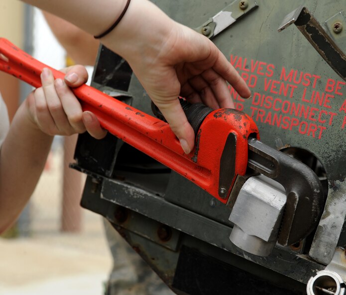 Airman 1st Class Kristen McConnell, 2nd Maintenance Squadron Accessories Flight Electrical and Environmental Section, tightens a monkey wrench around a filter on Barksdale Air Force Base, La., March 18. Electrical and environmental Airmen are in charge of maintaining the life support and electrical and power systems that run the aircraft. (U.S. Air Force photo/Airman 1st Class Benjamin Gonsier)
