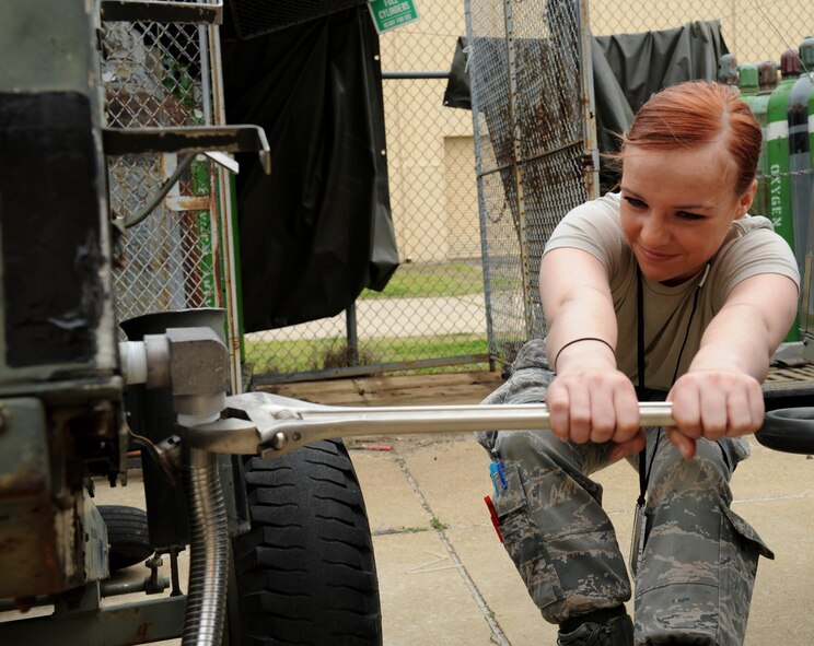 Airman 1st Class Kristen McConnell, 2nd Maintenance Squadron Accessories Flight Electrical and Environmental Section, pulls a wrench to disconnect a filter on a liquid oxygen servicing cart at Barksdale Air Force Base, La., March 18. Liquid oxygen is transferred to the B-52H Stratofortress and used to assist aircrew in breathing during flight. Electrical and Environmental Airmen maintain, drain, purge and repair the carts. (U.S. Air Force photo/Airman 1st Class Benjamin Gonsier)
