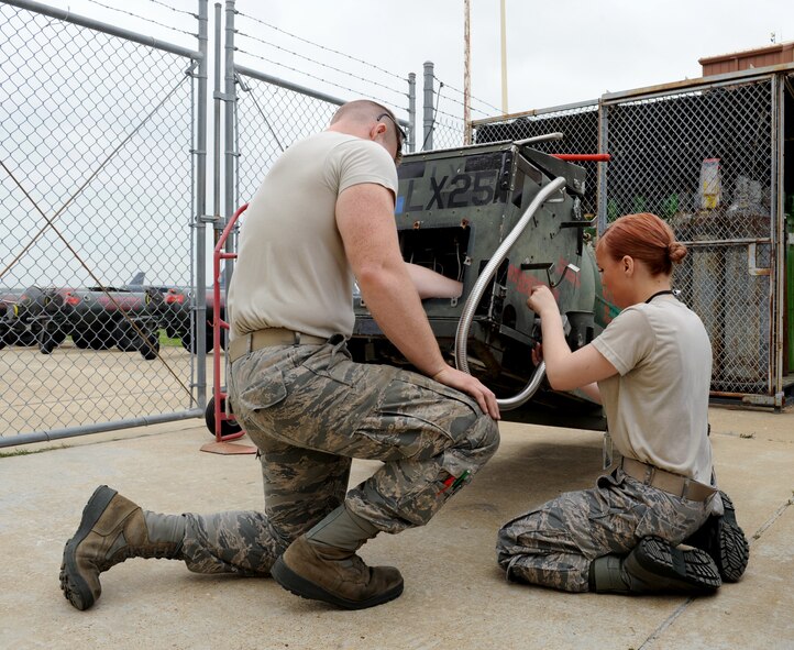 Airmen 1st Class Kristen McConnell and Charles Gage, 2nd Maintenance Squadron Accessories Flight Electrical and Environmental Section, loosen a bolt on a liquid oxygen servicing cart at Barksdale Air Force Base, La., March 18. Electrical and Environmental Airmen maintain, drain, purge and repair the carts. Liquid oxygen is transferred to the B-52H Stratofortress and used to assist aircrew in breathing during flight. (U.S. Air Force photo/Airman 1st Class Benjamin Gonsier)