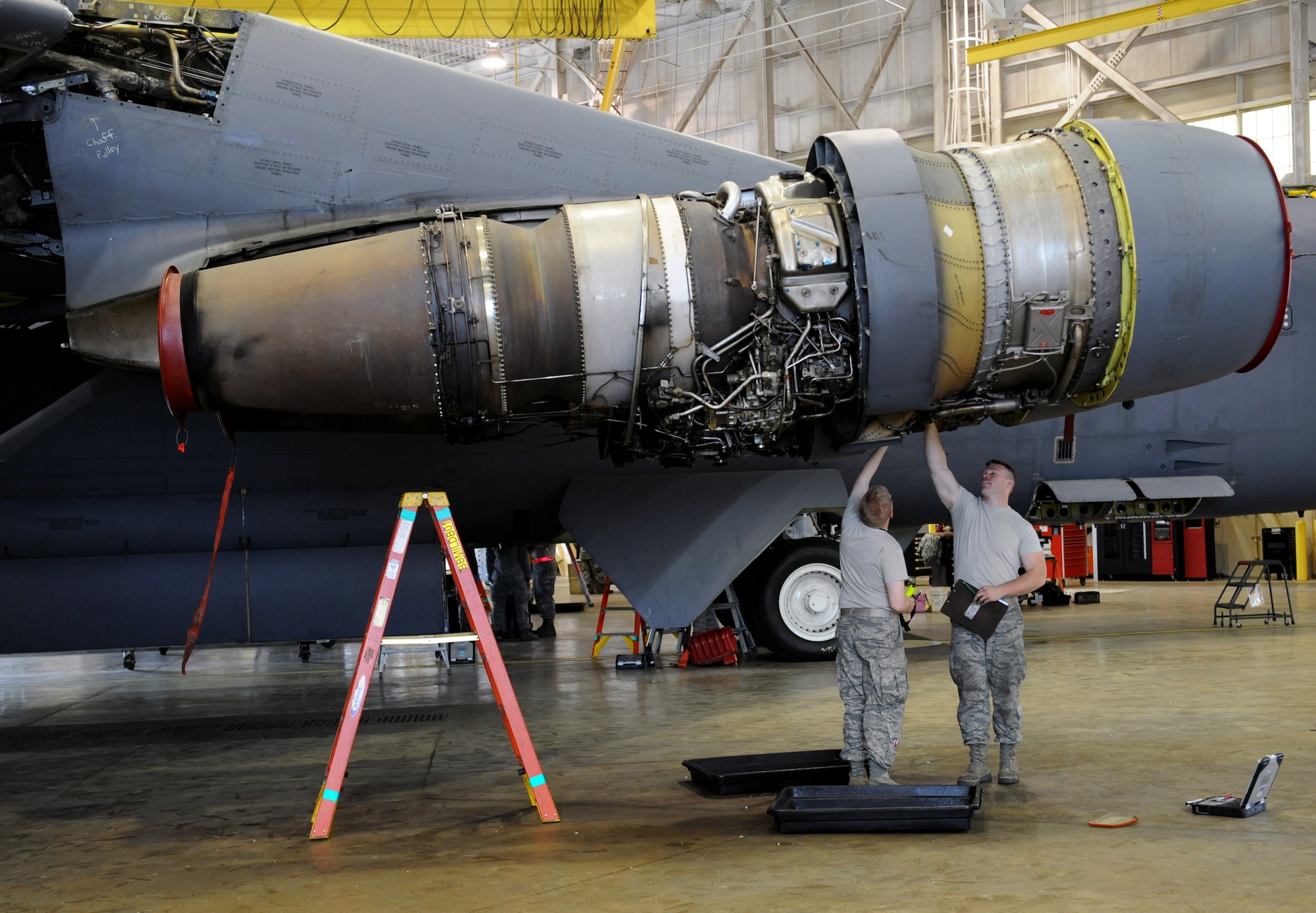 Airman Jesse Childress and Airman 1st Class Charles Gage, 2nd Maintenance Squadron Accessories Flight Electrical and Environmental Section, inspect the bottom of a B-52H Stratofortress engine for discrepancies on Barksdale Air Force Base, La., March 18. Electrical and environmental Airmen are in charge of maintaining the life support and electrical and power systems that run the aircraft. (U.S. Air Force photo/Airman 1st Class Benjamin Gonsier)