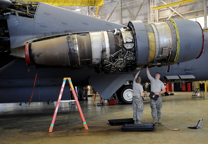 Airman Jesse Childress and Airman 1st Class Charles Gage, 2nd Maintenance Squadron Accessories Flight Electrical and Environmental Section, inspect the bottom of a B-52H Stratofortress engine for discrepancies on Barksdale Air Force Base, La., March 18. Electrical and environmental Airmen are in charge of maintaining the life support and electrical and power systems that run the aircraft. (U.S. Air Force photo/Airman 1st Class Benjamin Gonsier)