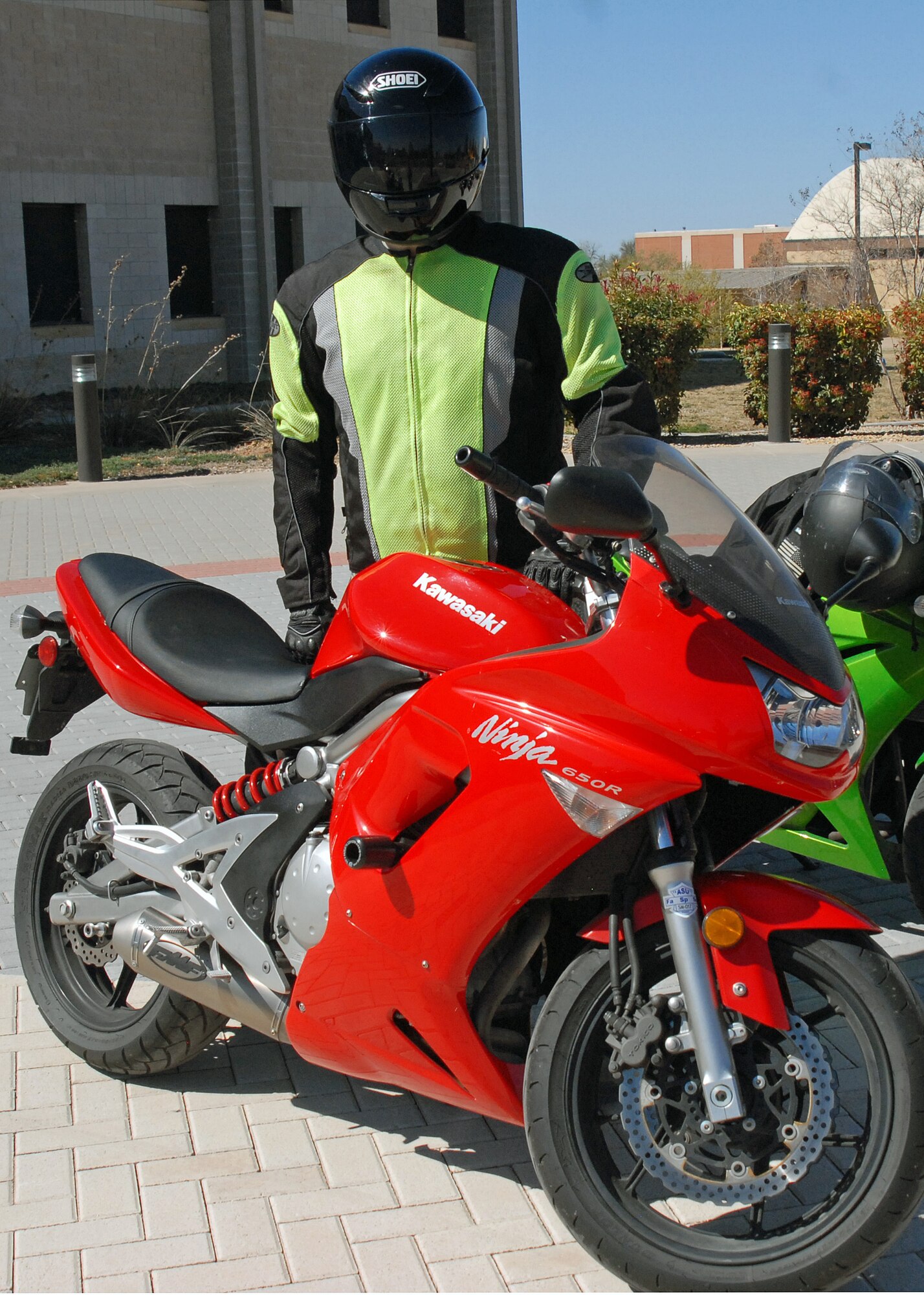 GOODFELLOW AIR FORCE BASE, Texas—Staff Sgt. Billy Pratt, 315th Training Squadron geospatial targeting course instructor, demonstrates the proper wear of personal protective equipment during a 17th Training Wing motorcycle safety representatives meeting here March 15. The Air Force requires motorcycle riders, including all Air Force military personnel and Air Force civilians in some situations, wear specific pieces of PPE including a helmet properly fastened under the chin; a full face shield or eye protection, such as impact-resistant goggles; long trousers; a long sleeved shirt or jacket; full-fingered gloves or mittens; sturdy, over-the-ankle footwear; a high-visibility garment, such as a fluorescent yellow-green vest, during the day; and a retro-reflective upper garment during the night. (U.S. Air Force photo/ Capt. Jennifer Richard)