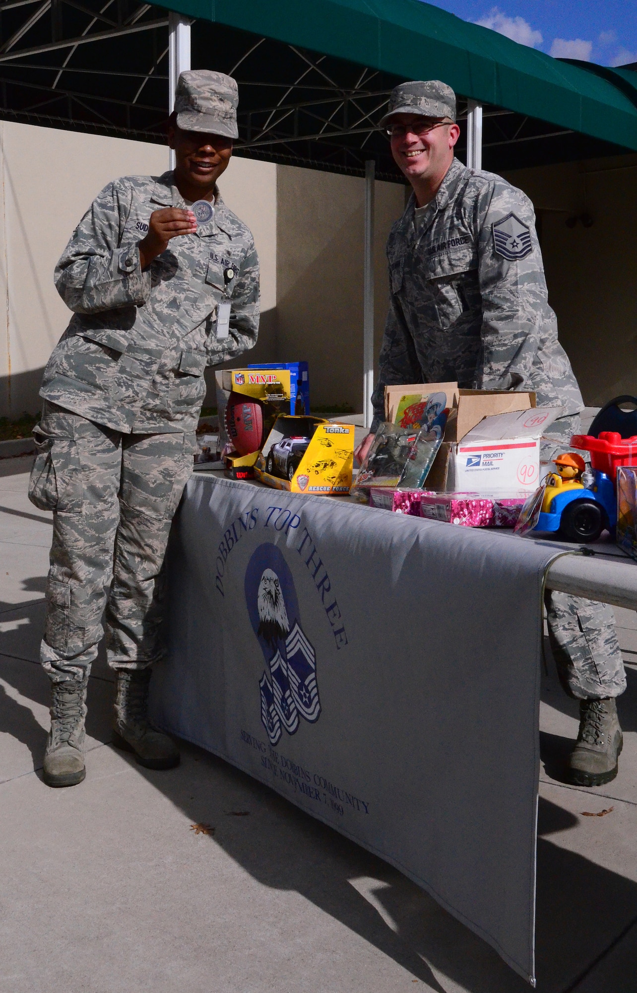Master Sgt. John Besselman, of the 94th Civil Engineering Squadron, mans the "Coins for Toys" table at the Dobbins Consolidated Club during the December unit training assembly. The Top Three collected $1400 in the form of toys this holiday season. (U.S. Air Force photo/Senior Airman Elizabeth Van Patten)