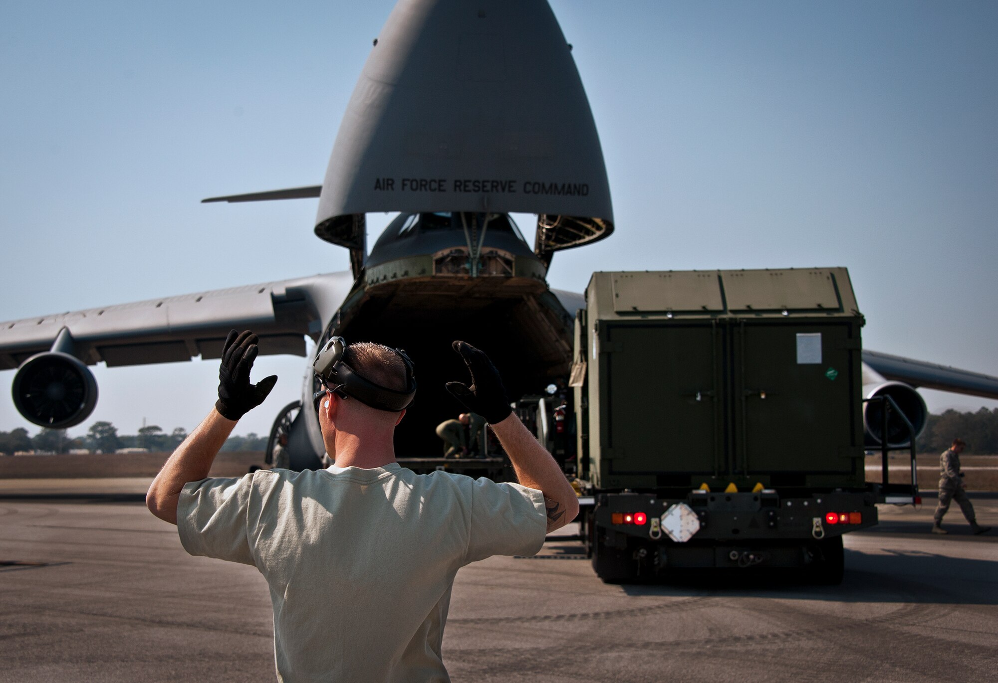 Staff Sgt. Robby Harrison, of the 96th Logistics Readiness Squadron, directs the loader back after picking up some maintenance equipment from a C-5 Galaxy March 14 at Eglin Air Force Base, Fla.  The air transportation Airmen unloaded approximately 103,165 pounds of maintenance equipment for an F-16 unit participating in a weapons system evaluation program March 18-22.  (U.S. Air Force photo/Samuel King Jr.)