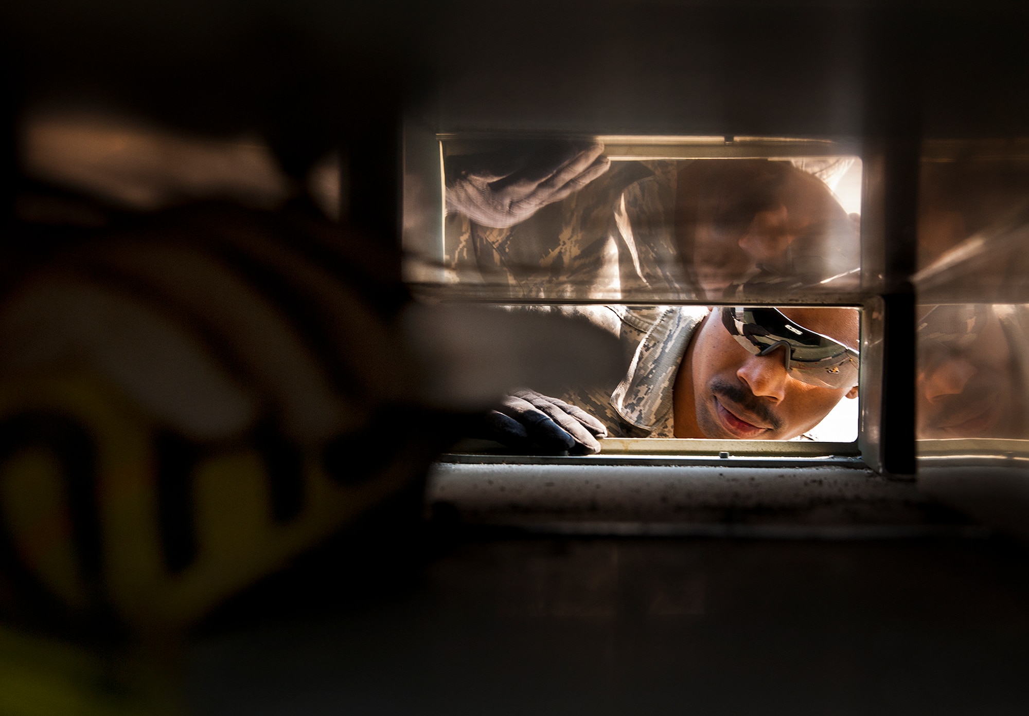 A member of the 482nd Fighter Wing waits to grab the tie-down strap to secure maintenance cargo to a flat-bed truck March 14 at Eglin Air Force Base, Fla.  The 96th Logistics Readiness Squadron Airmen unloaded approximately 103,165 pounds of maintenance equipment for the 482nd maintenance units participating in a weapons system evaluation program March 18-22.  (U.S. Air Force photo/Samuel King Jr.)