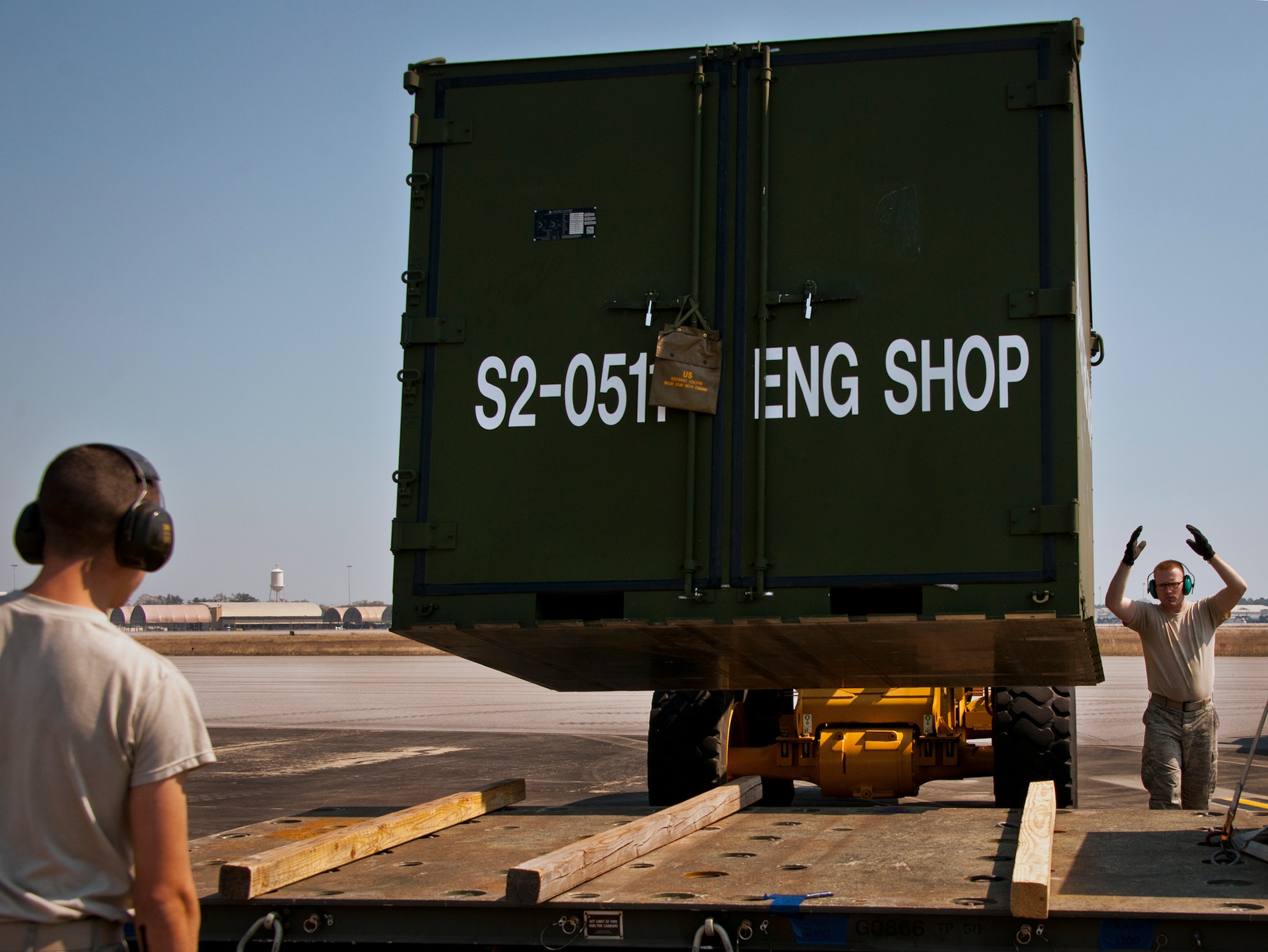 Senior Airman Kalipb Wiggins, of the 96th Logistics Readiness Squadron, directs the loader carrying maintenance equipment toward a trailer March 14 at Eglin Air Force Base, Fla.  The Airmen unloaded approximately 103,165 pounds of maintenance equipment for an F-16 unit participating in a weapons system evaluation program the following week.  (U.S. Air Force photo/Samuel King Jr.)
