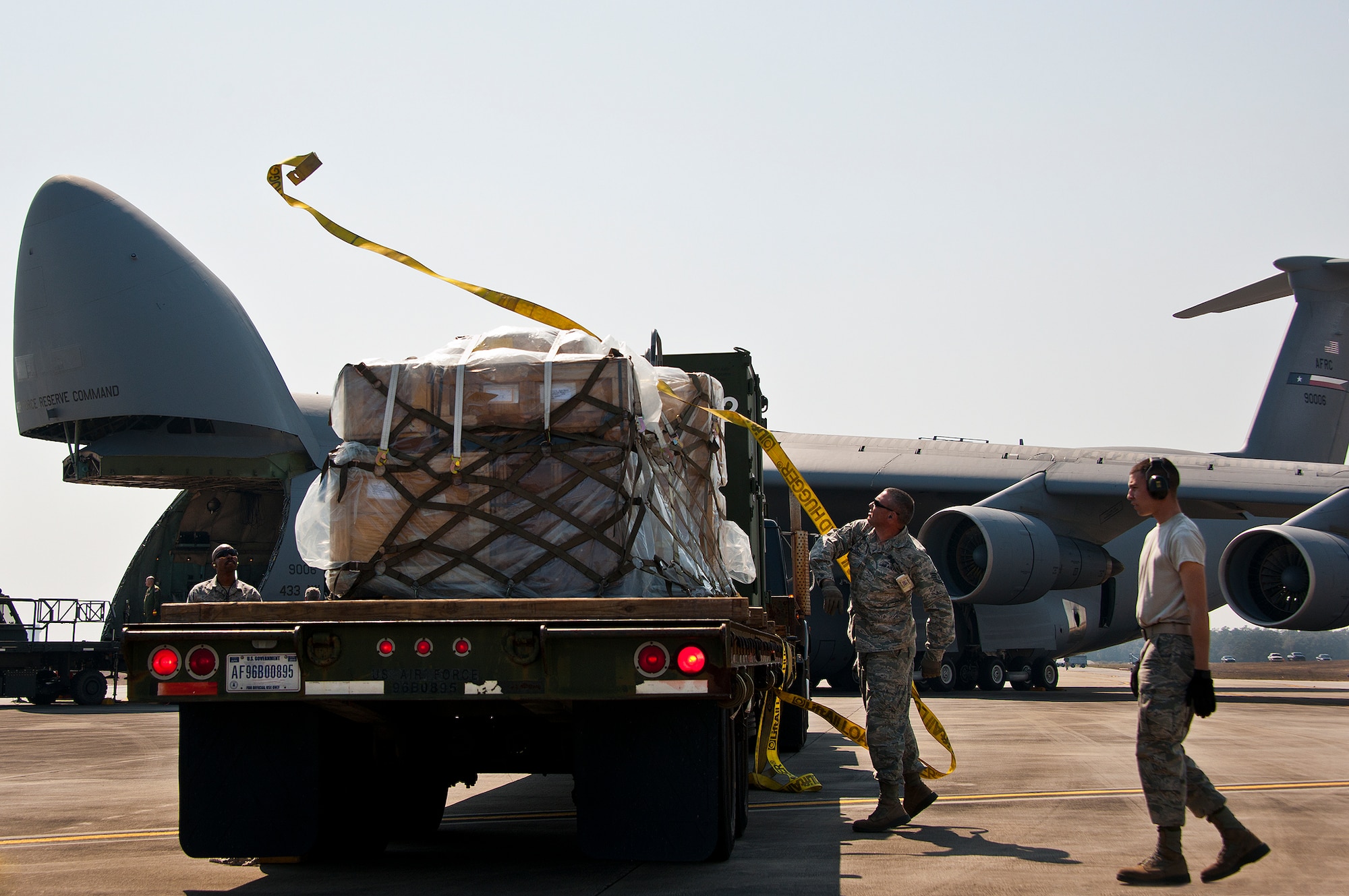 Tech Sgt. Russell Guajardo, of the 482nd Fighter Wing, flings a strap over the maintenance equipment on a flat-bed truck March 14 at Eglin Air Force Base, Fla.  The 96th Logistics Readiness Squadron Airmen unloaded approximately 103,165 pounds of maintenance equipment for the 482nd maintenance units participating in a weapons system evaluation program March 18-22.  (U.S. Air Force photo/Samuel King Jr.)