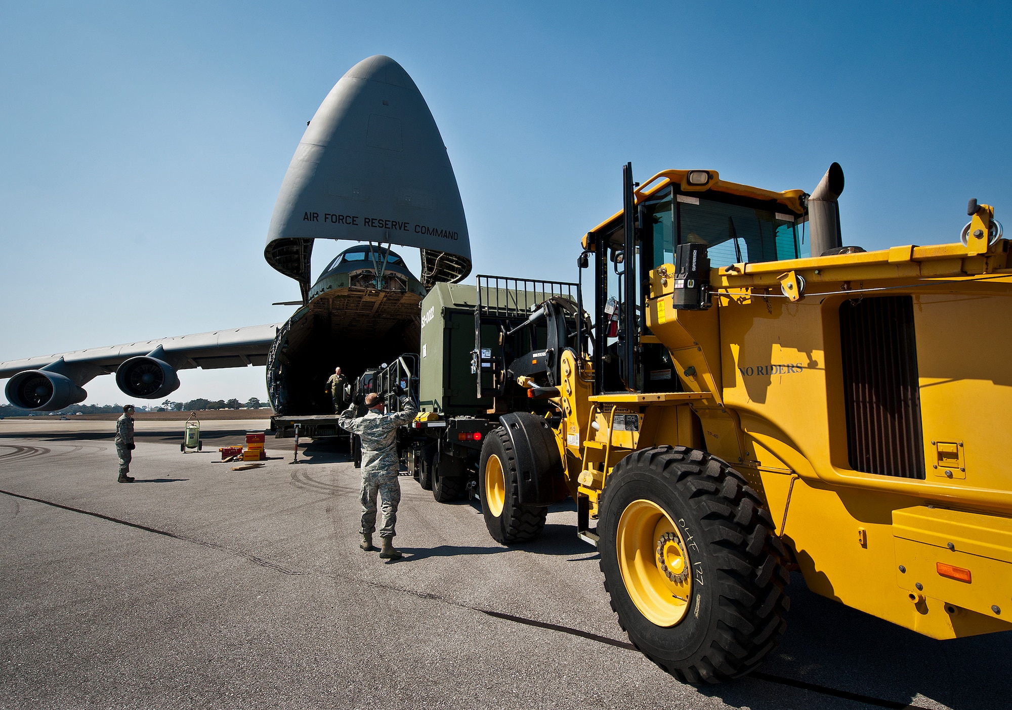 Staff Sgt. Robby Harrison, of the 96th Logistics Readiness Squadron, directs the loader forward to pick up maintenance equipment from a C-5 Galaxy March 14 at Eglin Air Force Base, Fla.  The Airmen unloaded approximately 103,165 pounds of maintenance equipment for an F-16 unit participating in a weapons system evaluation program March 18-22.  (U.S. Air Force photo/Samuel King Jr.)