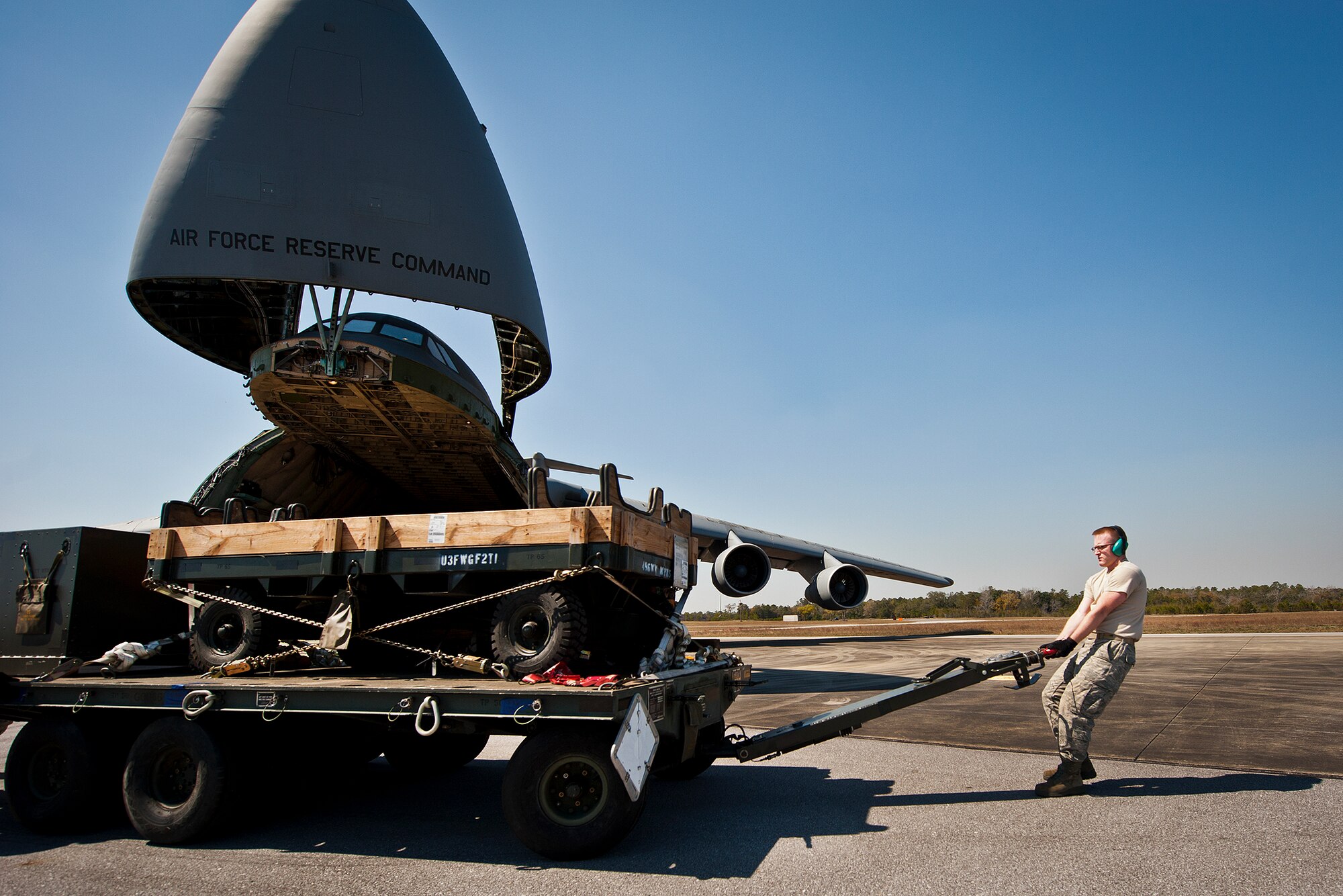 Senior Airman Kalipb Wiggins, of the 96th Logistics Readiness Squadron, moves a piece of equipment away from a C-5 Galaxy March 14 at Eglin Air Force Base, Fla.  The Airmen unloaded approximately 103,165 pounds of maintenance equipment for an F-16 unit participating in a weapons system evaluation program March 18-22.  (U.S. Air Force photo/Samuel King Jr.)