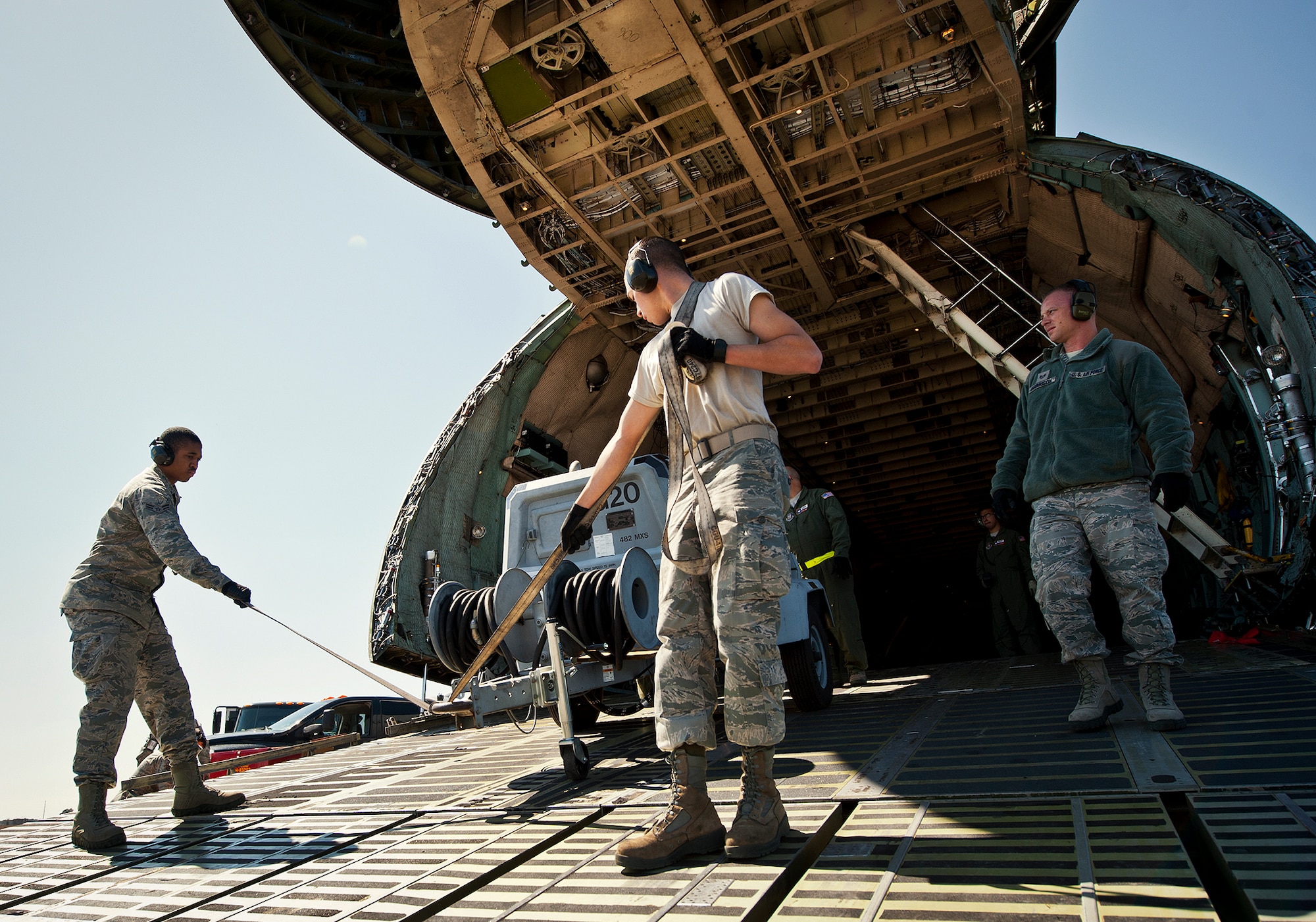 Airmen 1st Class Jamal Johnson (left) and Josh Wilson move a piece of equipment down the ramp of a C-5 Galaxy March 14 at Eglin Air Force Base, Fla.  The Airmen unloaded approximately 103,165 pounds of maintenance equipment for an F-16 unit participating in a weapons system evaluation program March 18-22.  (U.S. Air Force photo/Samuel King Jr.)