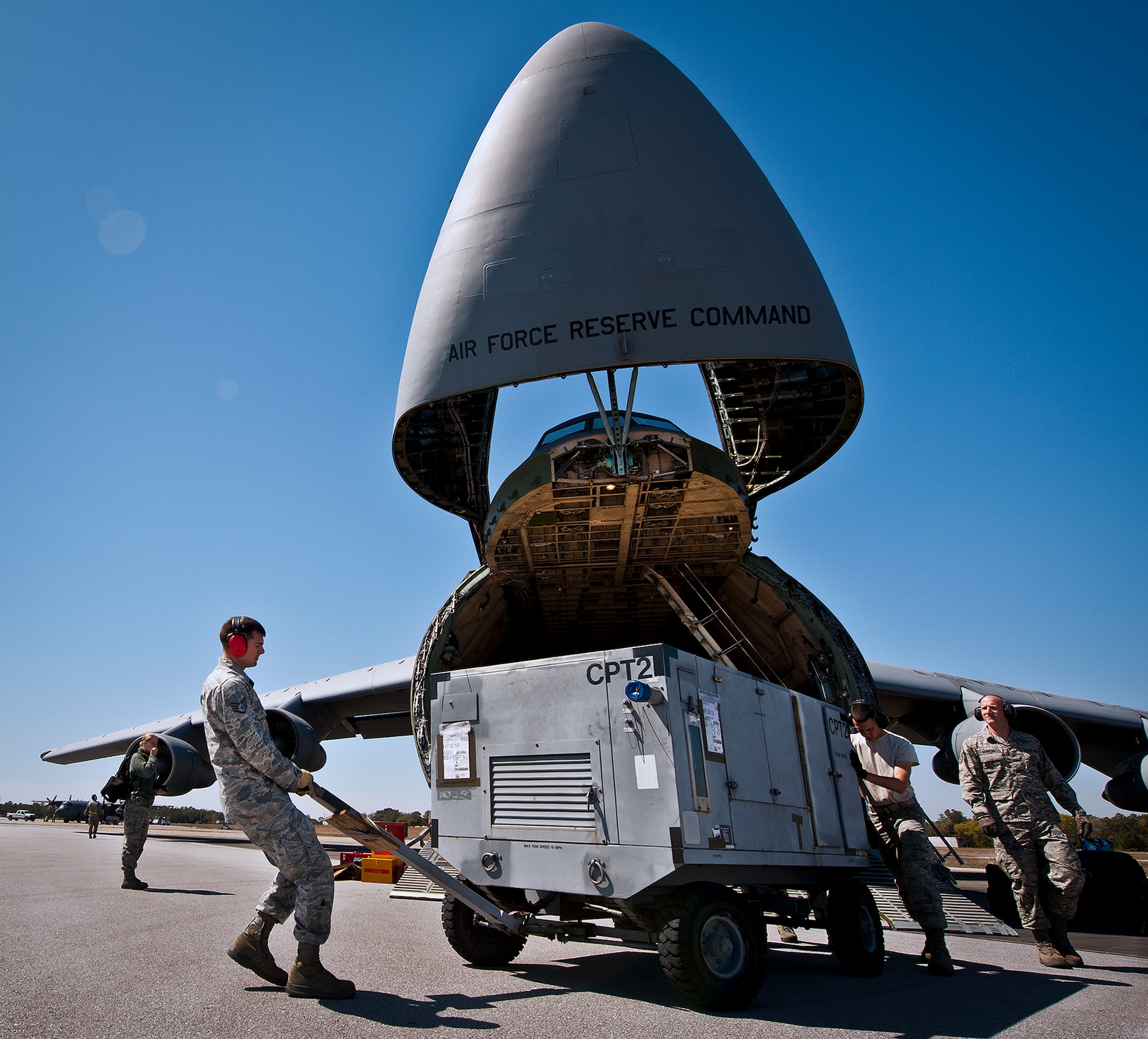 Staff Sgt. Darryl Leytham and Airman 1st Class Josh Wilson, of the 96th Logistics Readiness Squadron, move a generator away from a C-5 Galaxy March 14 at Eglin Air Force Base, Fla.  The Airmen unloaded approximately 103,165 pounds of maintenance equipment for an F-16 unit participating in a weapons system evaluation program the following week.  (U.S. Air Force photo/Samuel King Jr.)