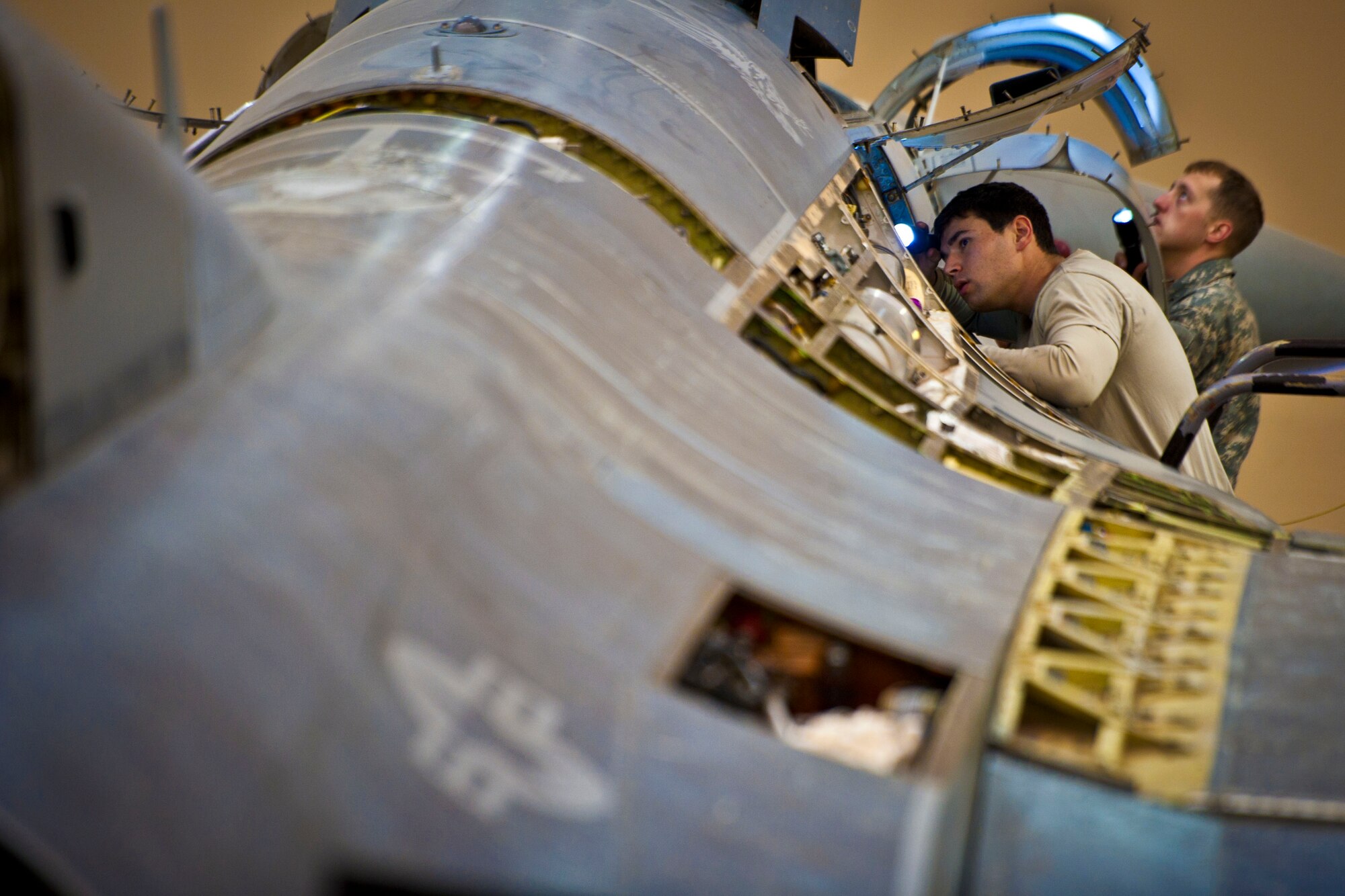 Senior Airmen Nicolas Azar and Frank Williams, 451st Expeditionary Maintenance Squadron aircraft maintainers, inspect an F-16 Fighting Falcon during a 400-flight-hour phase inspection at Kandahar Airfield, Afghanistan, Feb. 26, 2013. The 451st inspects everything on the aircraft from leaks or cracks to anything that may jeopardize the integrity of the aircraft. (U.S. Air Force photo/Senior Airman Scott Saldukas)